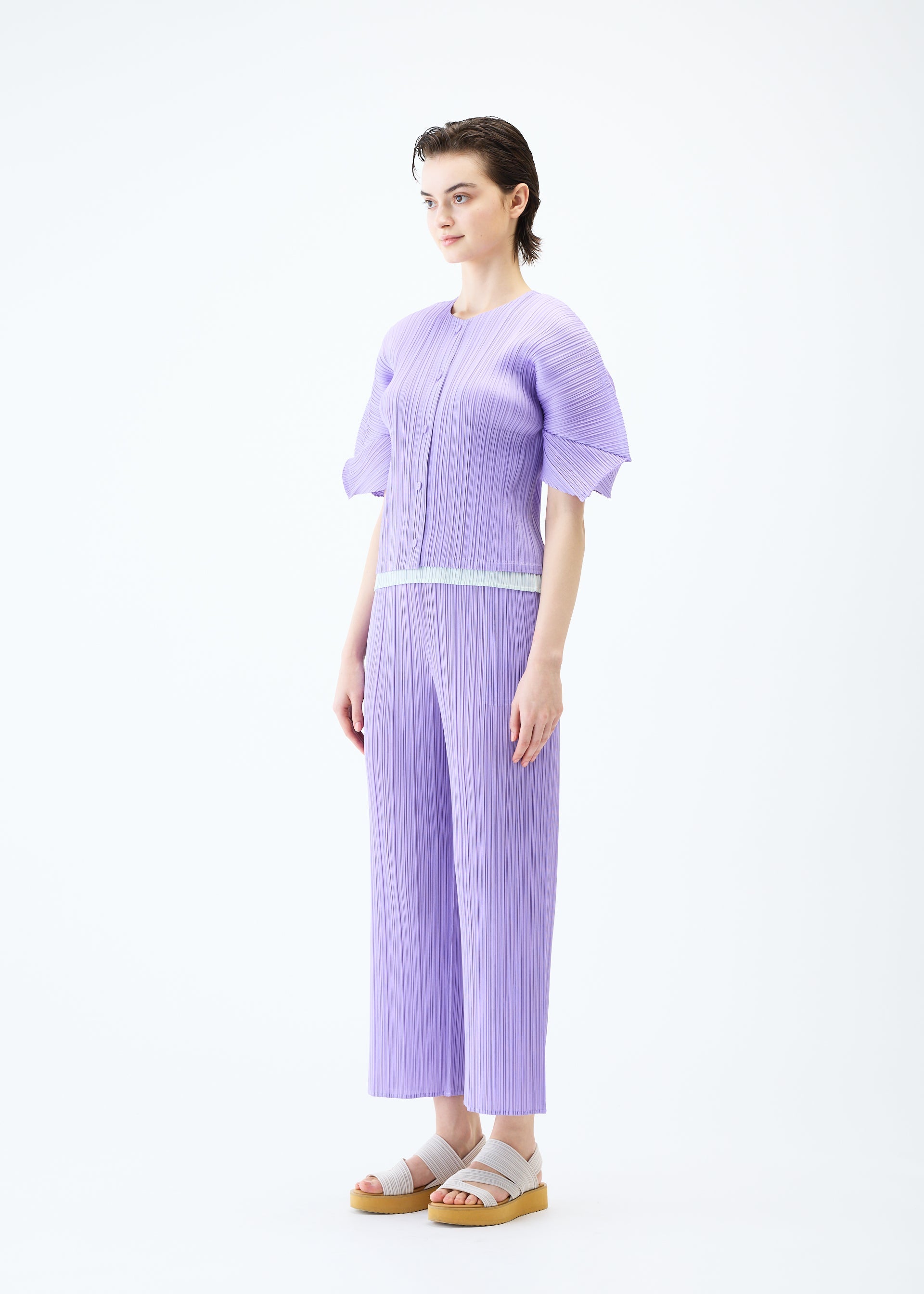 A model wears the PLEATS PLEASE ISSEY MIYAKE MONTHLY COLORS APRIL cardigan.