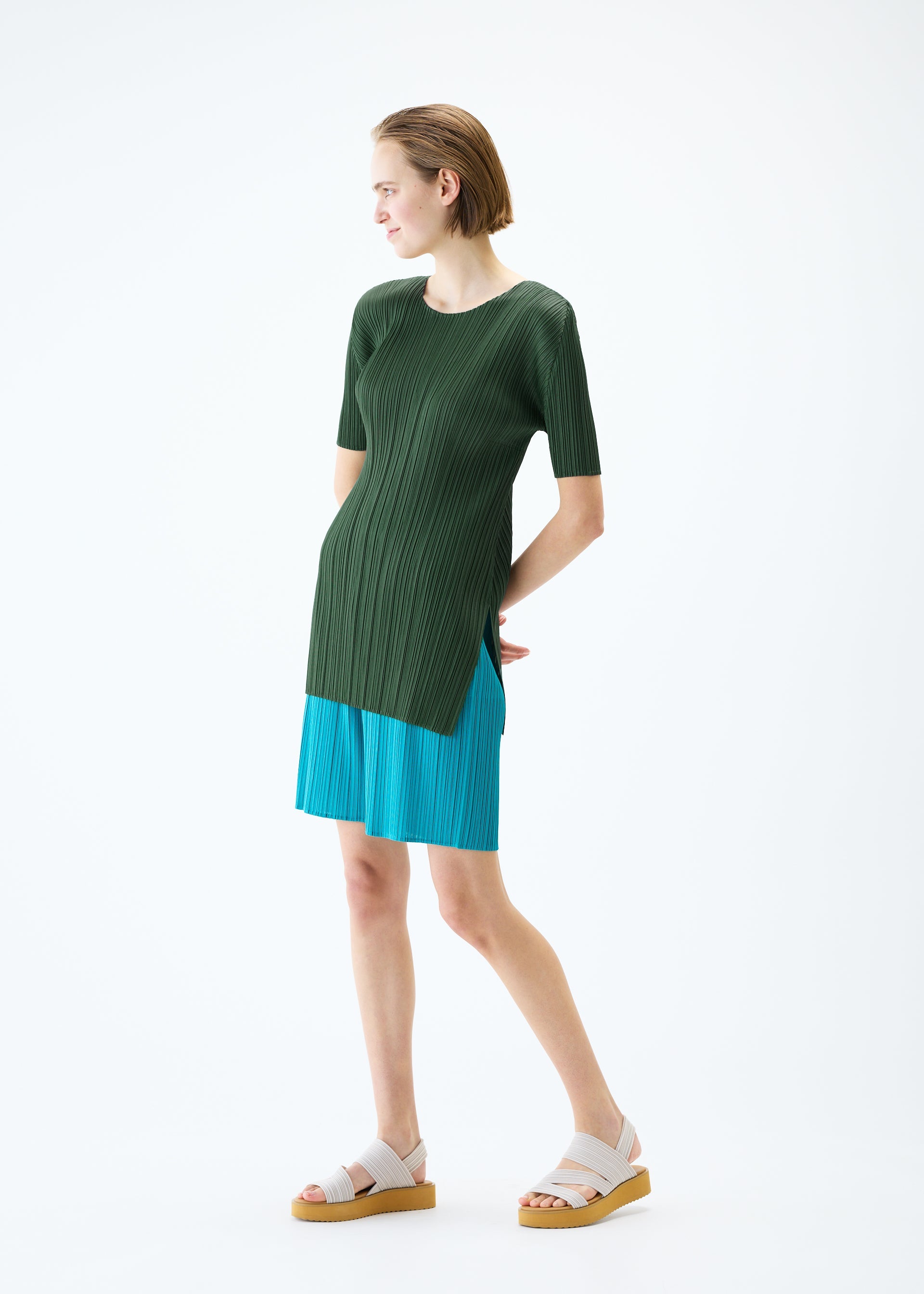 A model wears the PLEATS PLEASE ISSEY MIYAKE MONTHLY COLORS : JUNE tunic.