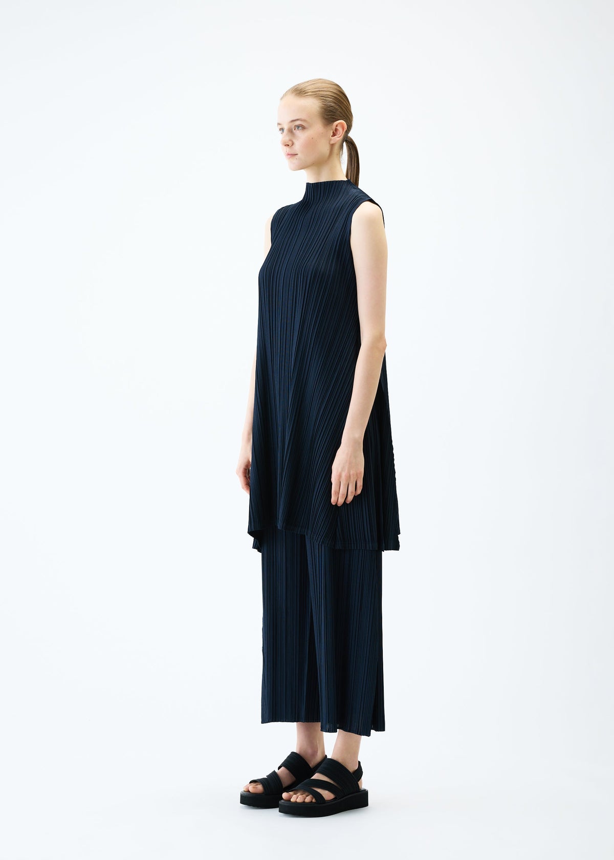 A model wears the PLEATS PLEASE ISSEY MIYAKE MELLOW PLEATS tunic.