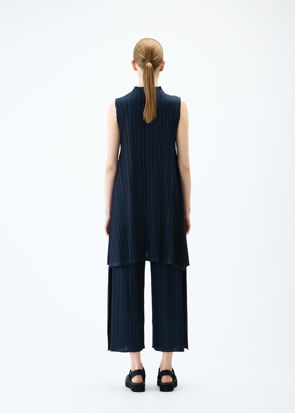 A model wears the PLEATS PLEASE ISSEY MIYAKE MELLOW PLEATS tunic.