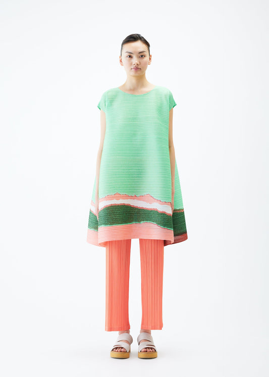 A model wears the PLEATS PLEASE ISSEY MIYAKE GRAINY COLORS tunic.
