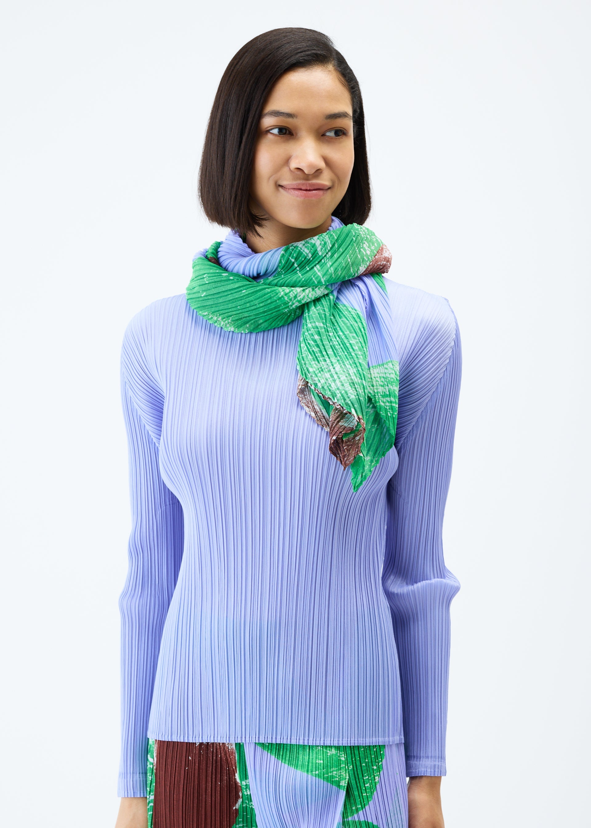 A model wears the PLEATS PLEASE ISSEY MIYAKE BACKLIGHT SCARF stole.