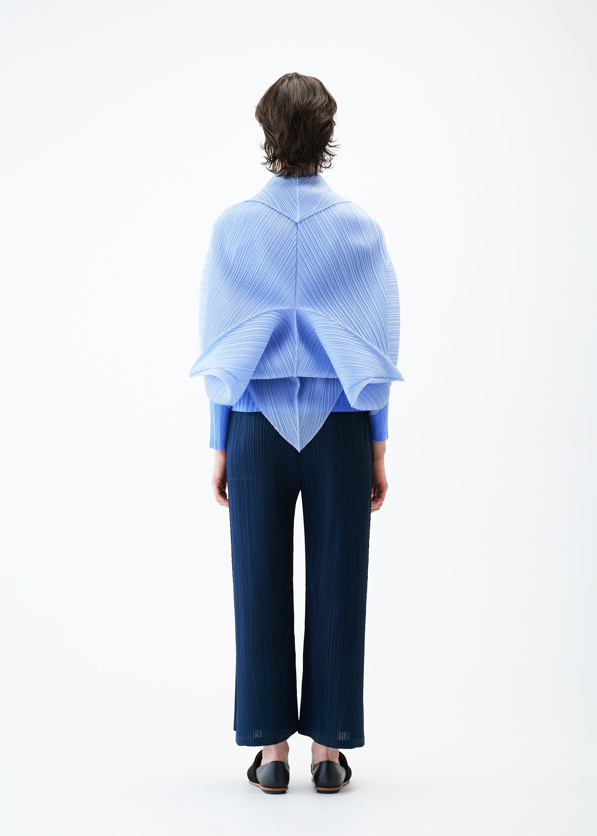 A model wears the PLEATS PLEASE ISSEY MIYAKE ZIGZAG PLEATS SCARF stole.
