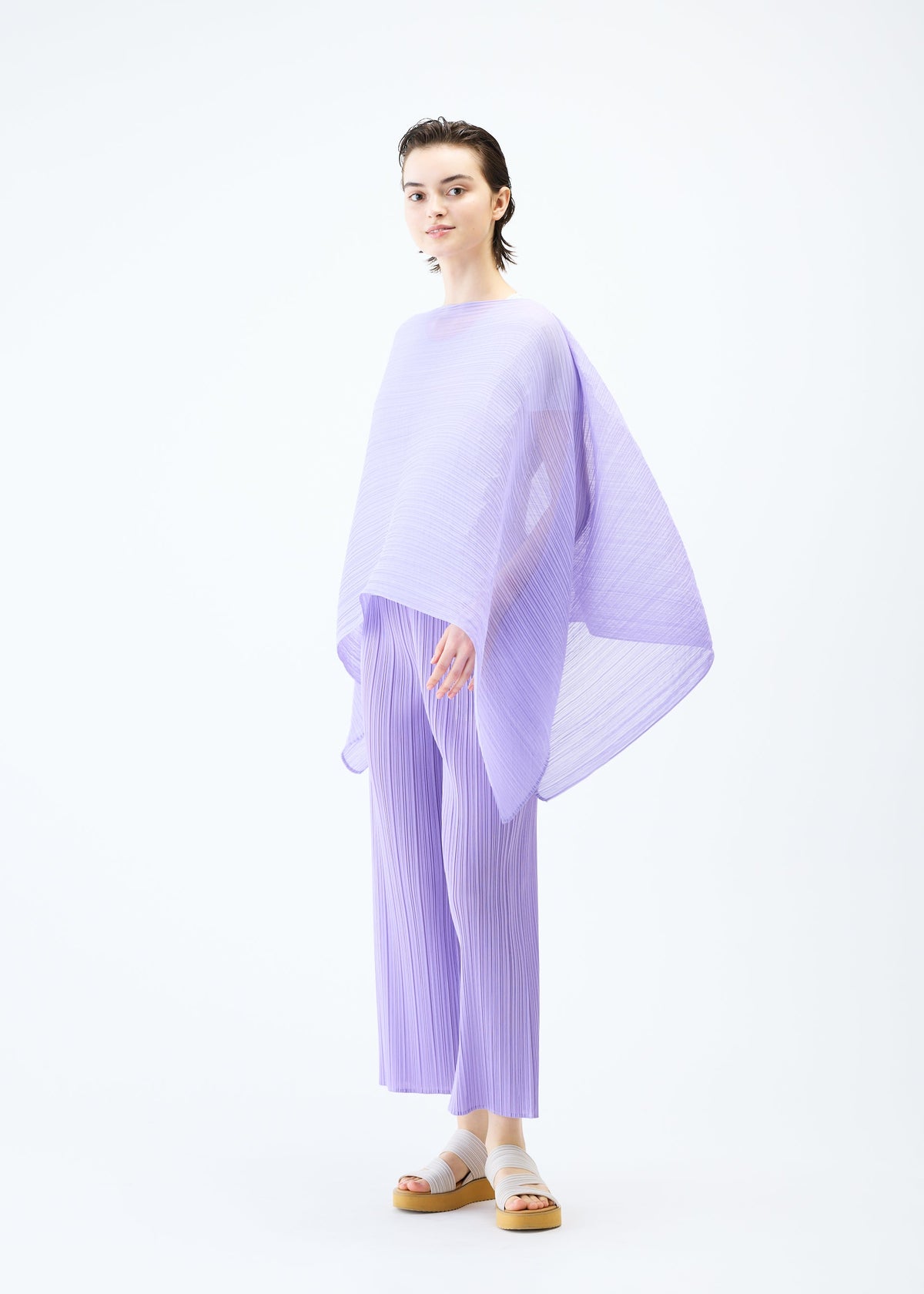 A model wears the PLEATS PLEASE ISSEY MIYAKE MADAME T APRIL stole.