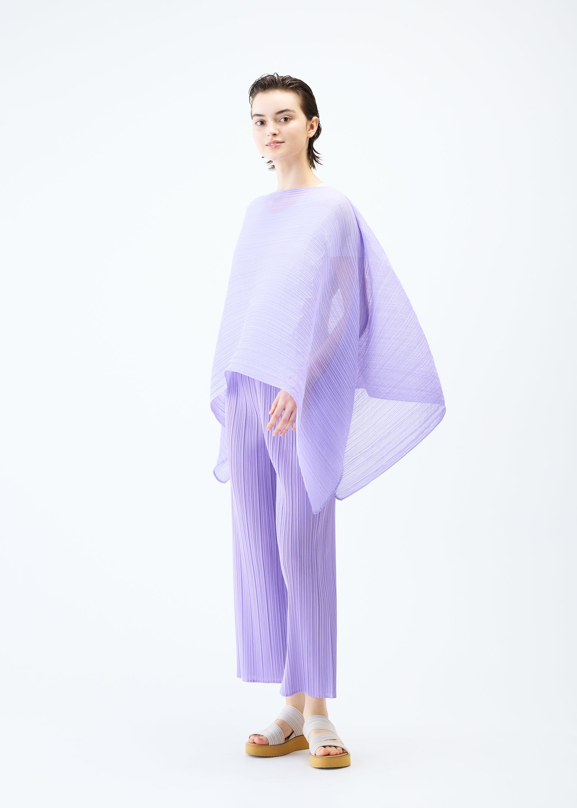 A model wears the PLEATS PLEASE ISSEY MIYAKE MADAME T APRIL stole.