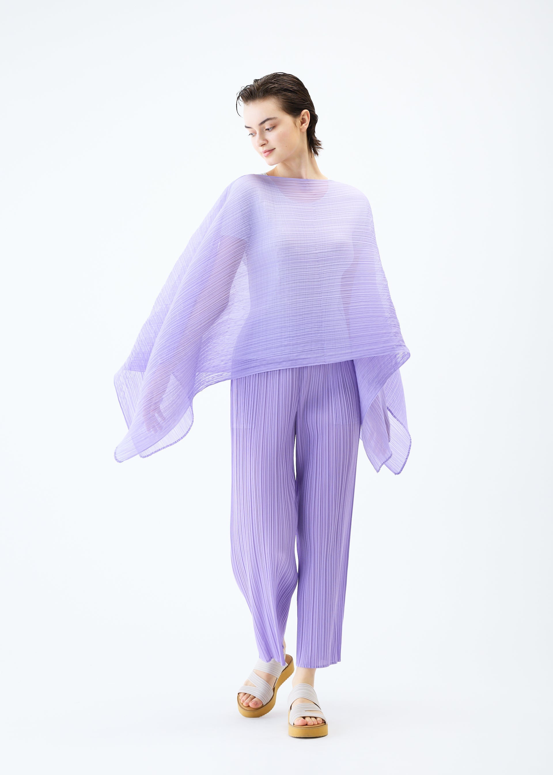 A model wears the PLEATS PLEASE ISSEY MIYAKE MADAME T APRIL stole.