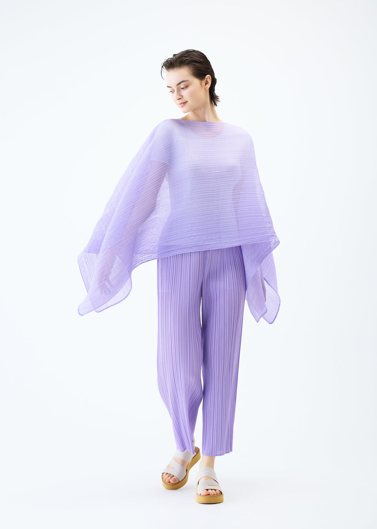 A model wears the PLEATS PLEASE ISSEY MIYAKE MADAME T APRIL stole.