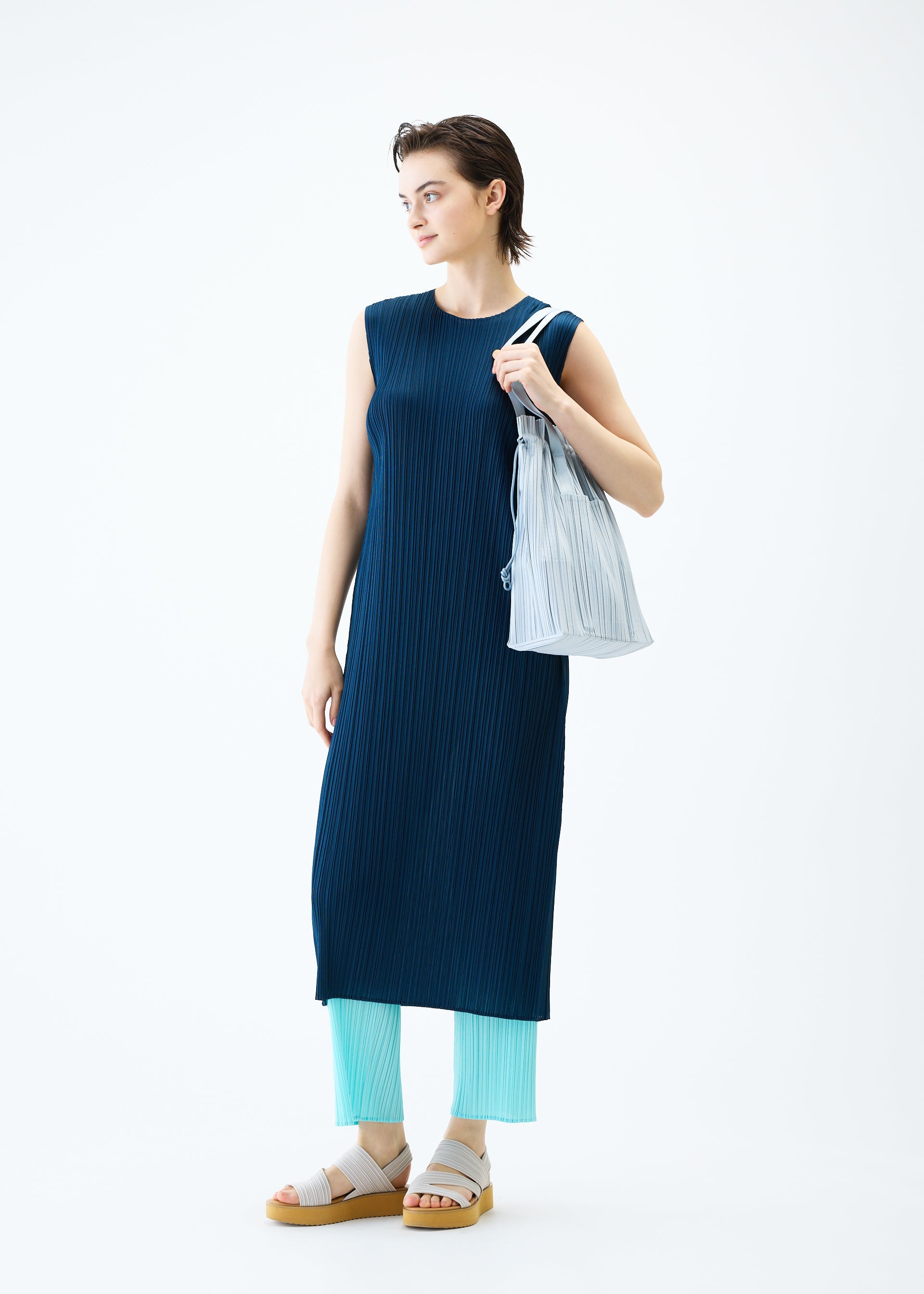 A model wears the PLEATS PLEASE ISSEY MIYAKE PLEATS TOTE BAG bag.