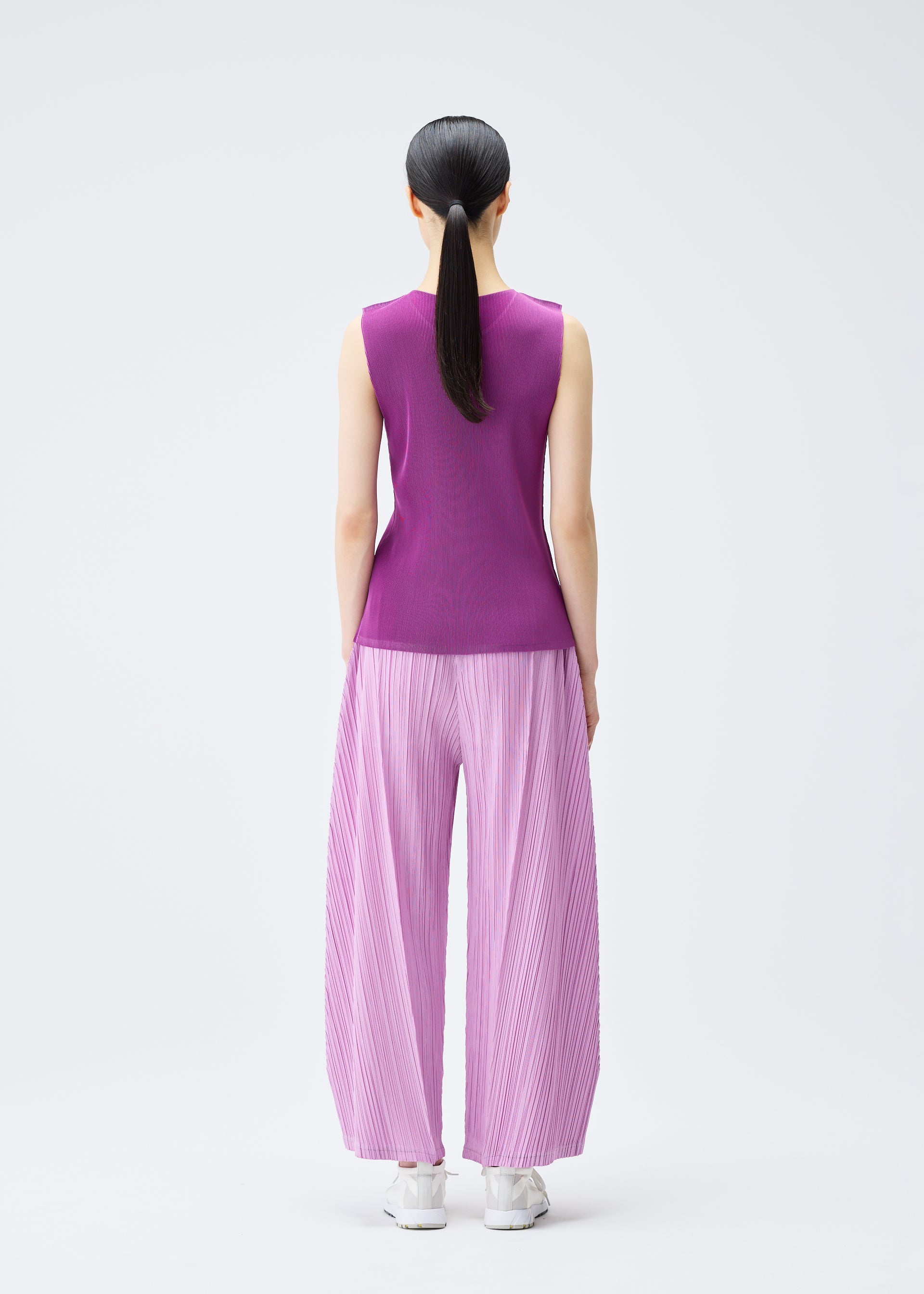 A model wears the PLEATS PLEASE ISSEY MIYAKE MIST SEPTEMBER top.