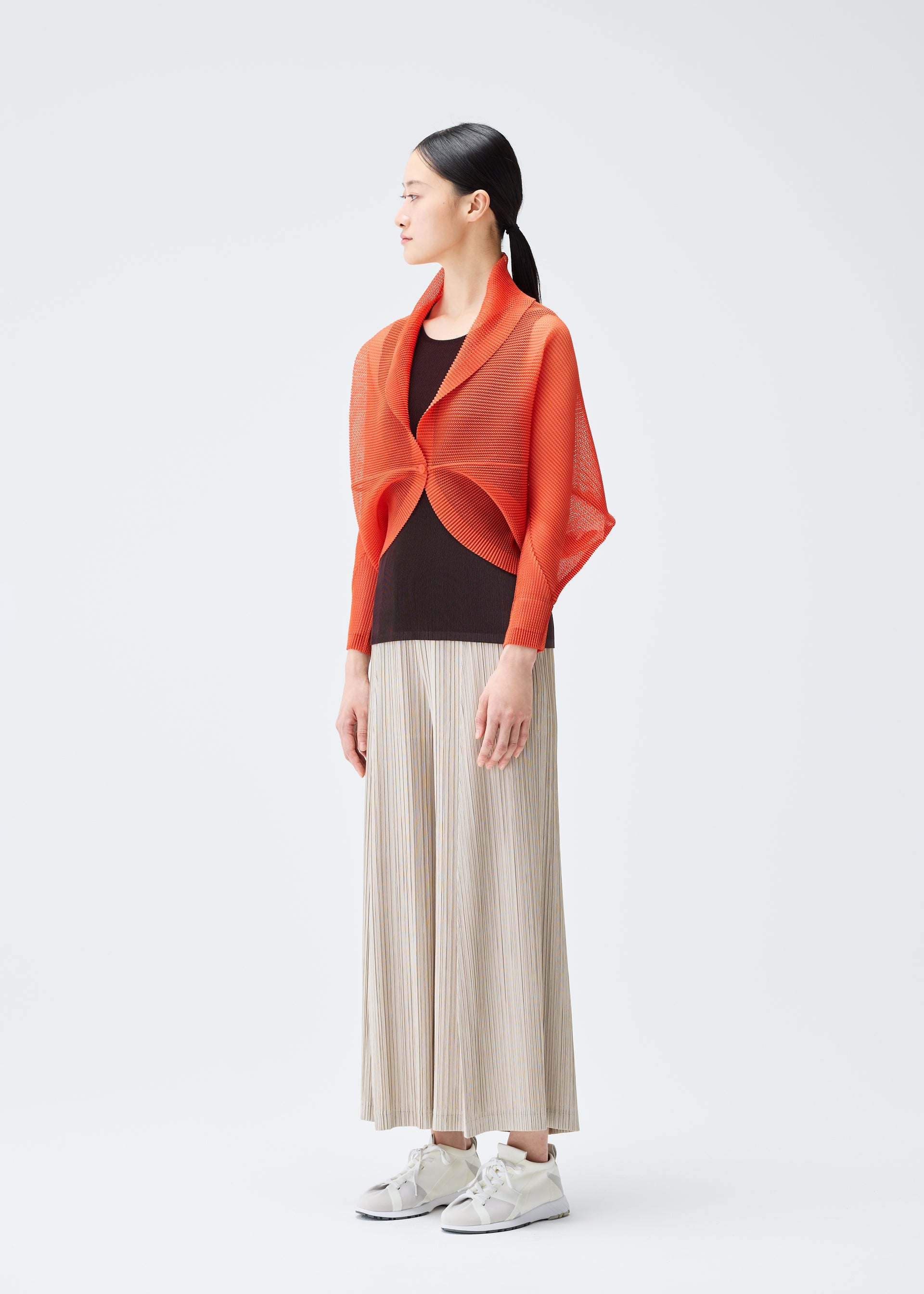 A model wears the PLEATS PLEASE ISSEY MIYAKE TATAMI JULY cardigan.