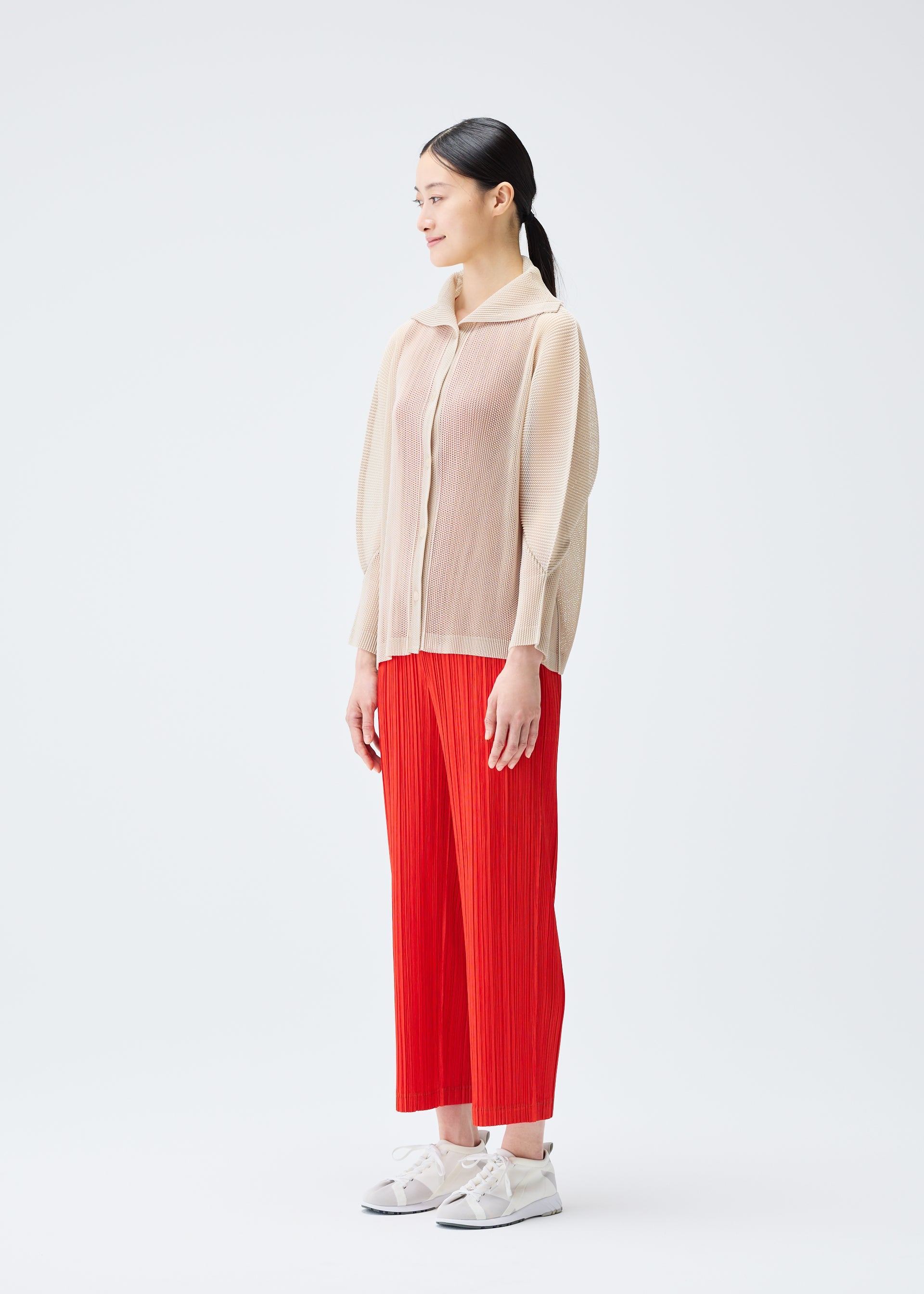 A model wears the PLEATS PLEASE ISSEY MIYAKE TATAMI JULY cardigan.