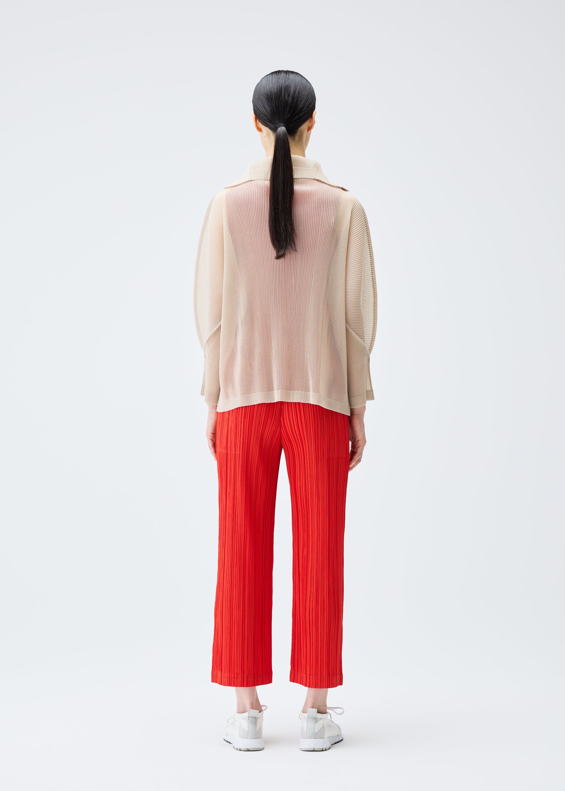 A model wears the PLEATS PLEASE ISSEY MIYAKE TATAMI JULY cardigan.