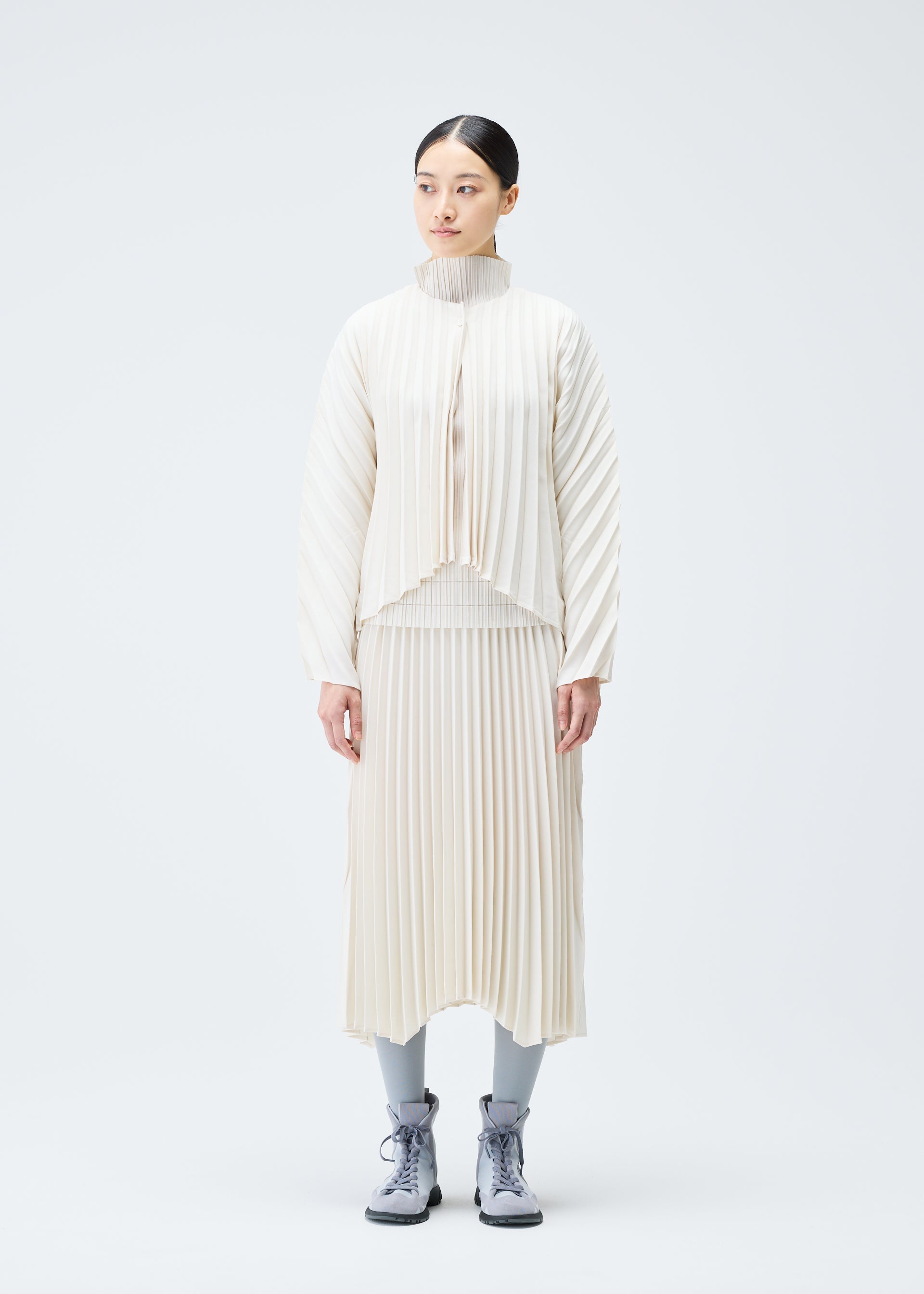 A model wears the PLEATS PLEASE ISSEY MIYAKE CIRCULAR cardigan.