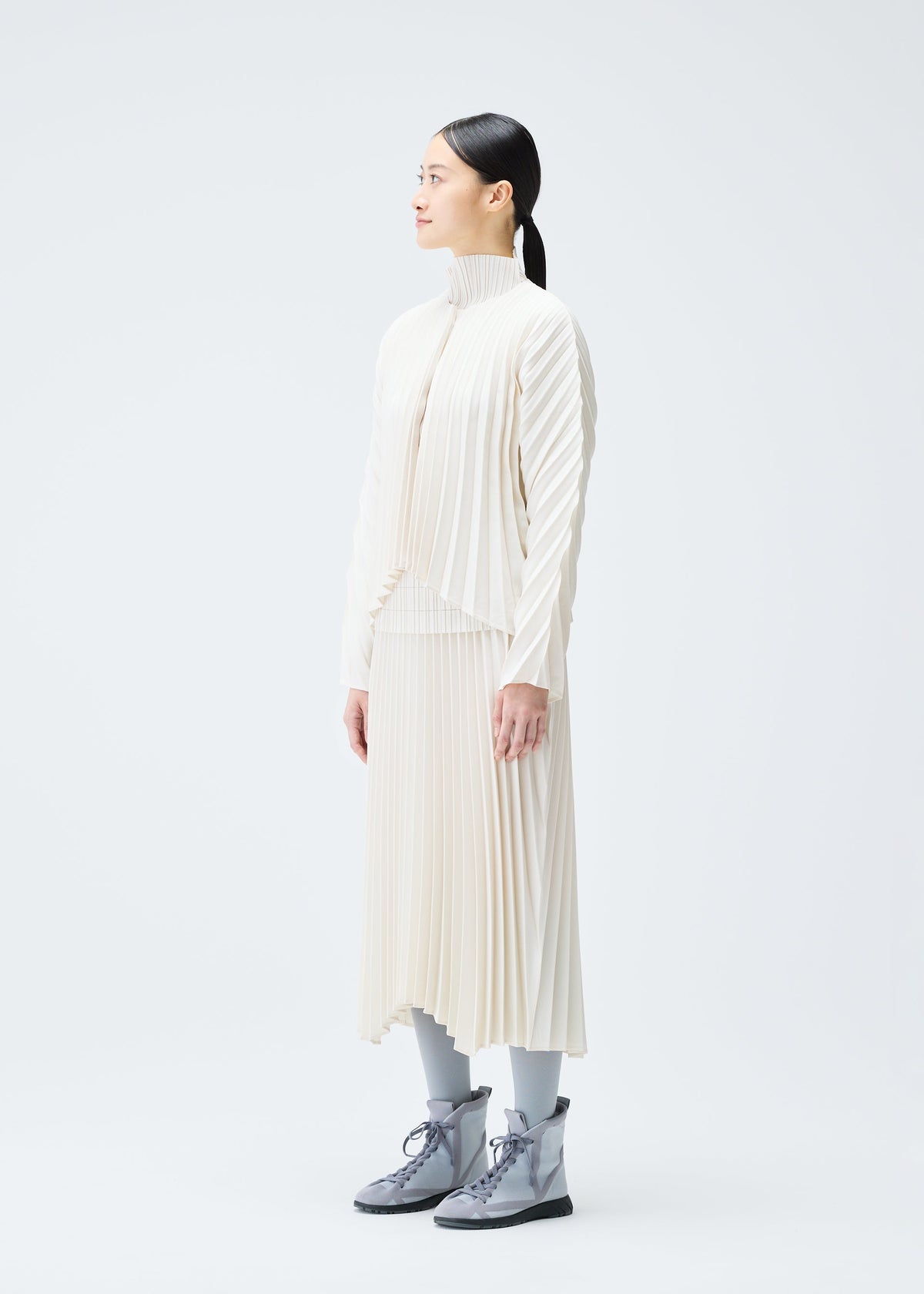 A model wears the PLEATS PLEASE ISSEY MIYAKE CIRCULAR cardigan.