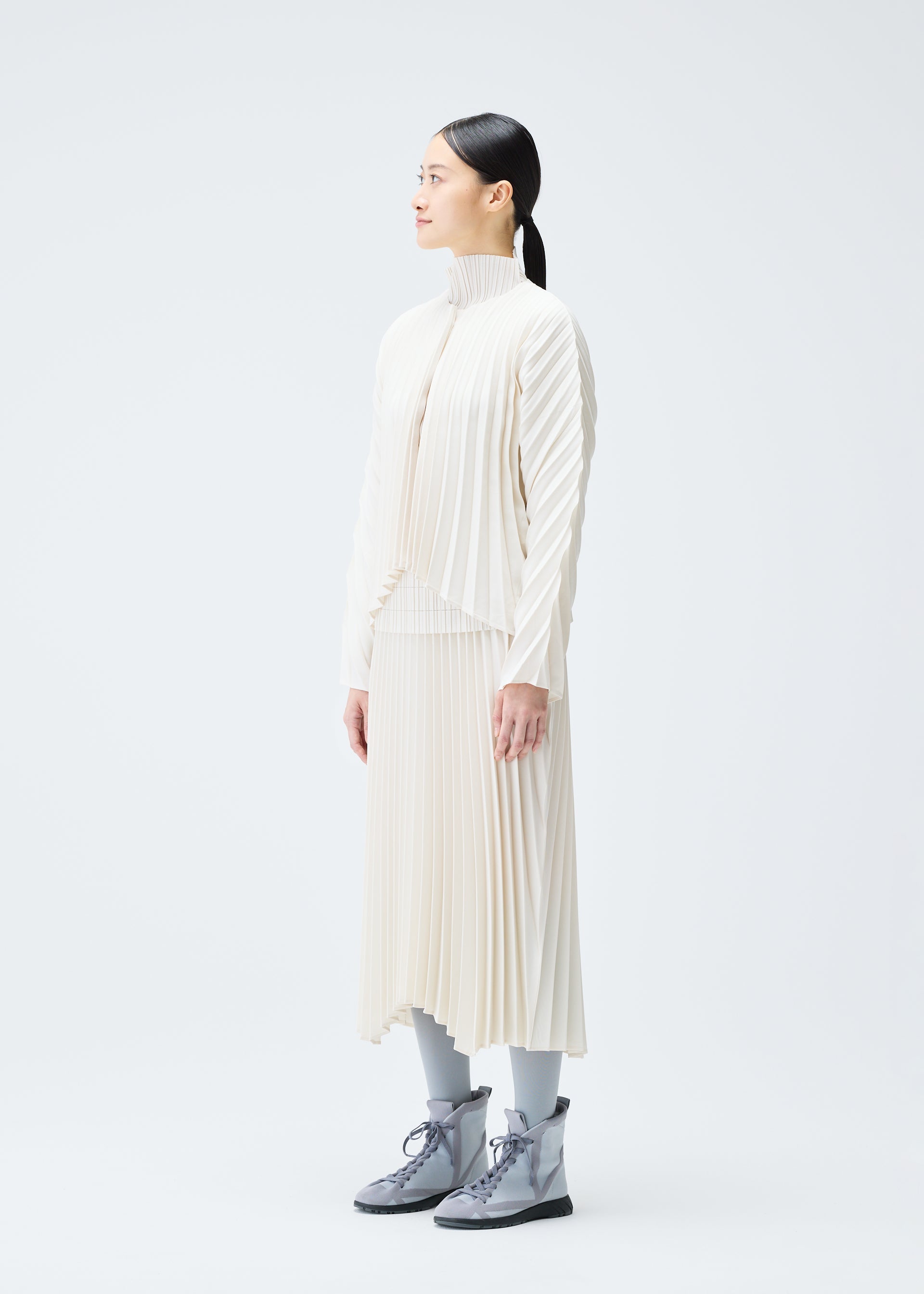 A model wears the PLEATS PLEASE ISSEY MIYAKE CIRCULAR cardigan.