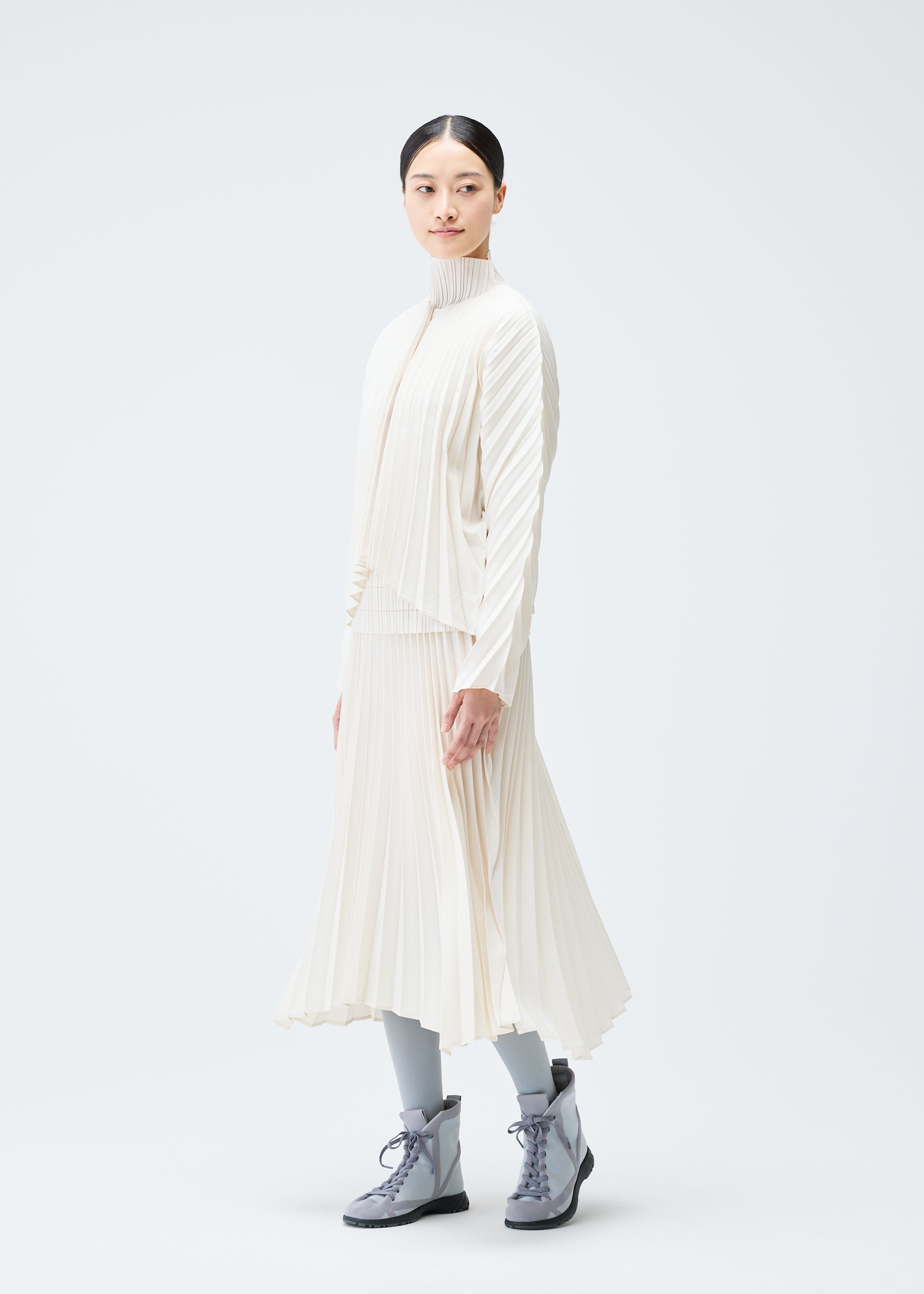 A model wears the PLEATS PLEASE ISSEY MIYAKE CIRCULAR cardigan.