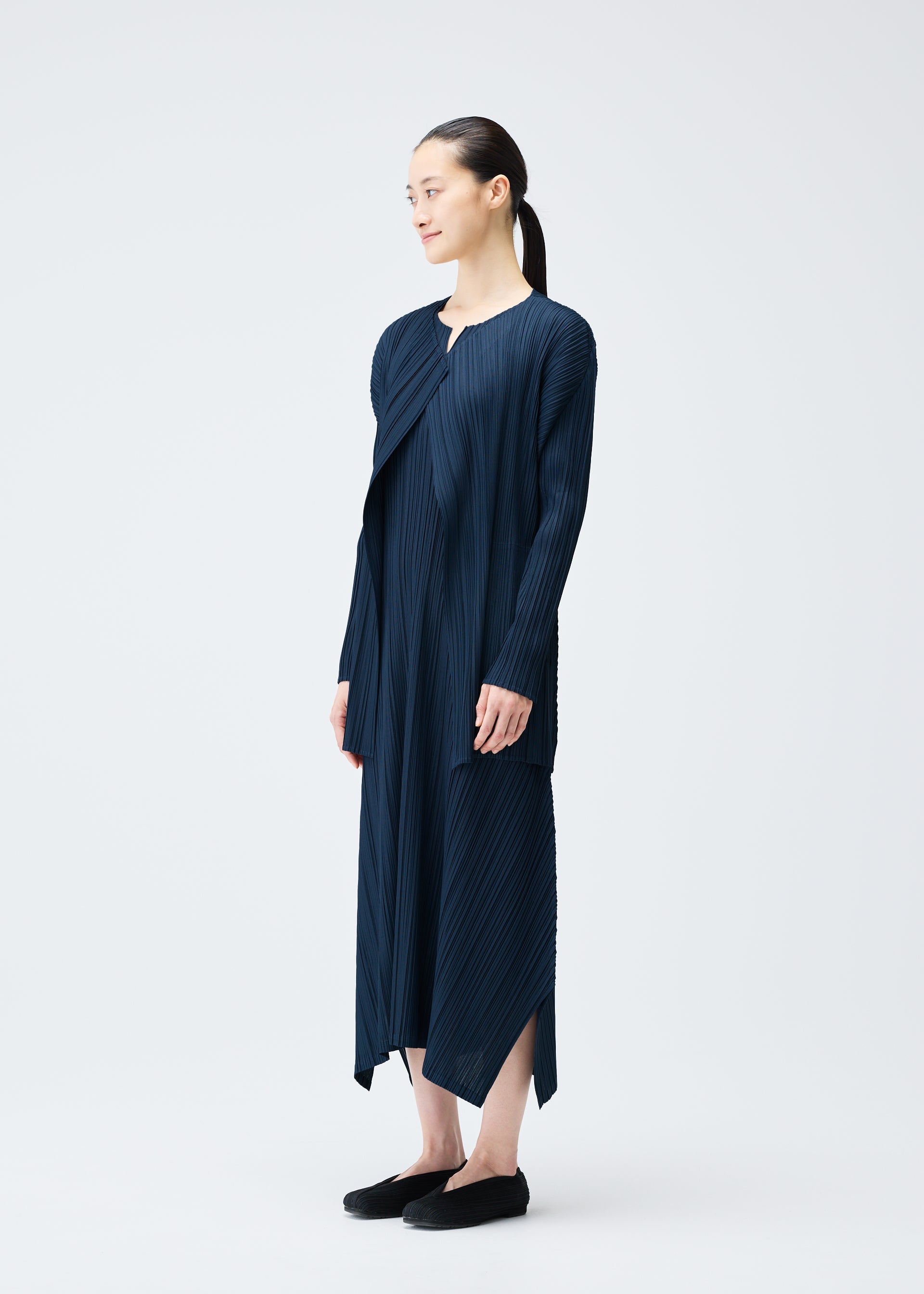 A model wears the PLEATS PLEASE ISSEY MIYAKE MELLOW PLEATS coat.