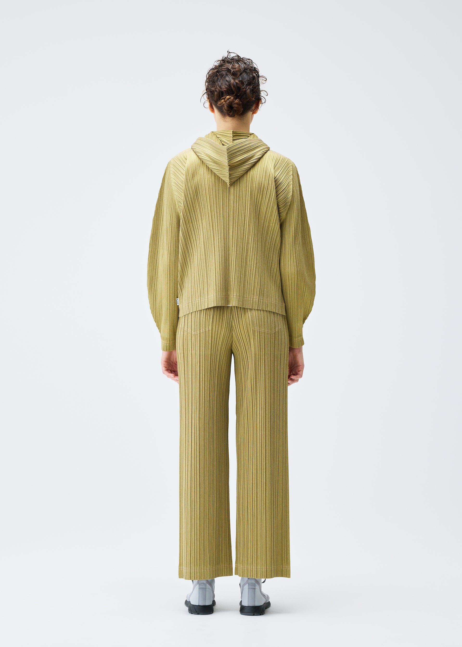 A model wears the PLEATS PLEASE ISSEY MIYAKE COTTON DENIM jacket.