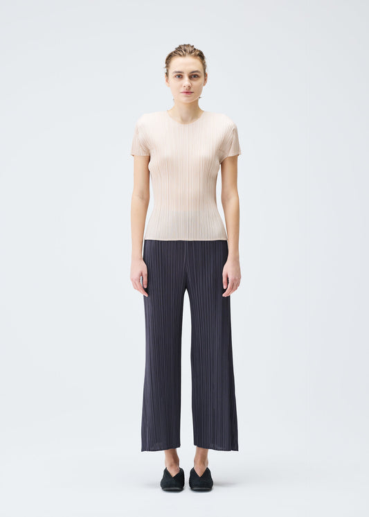 A model wears the PLEATS PLEASE ISSEY MIYAKE MONTHLY COLORS JULY trousers.