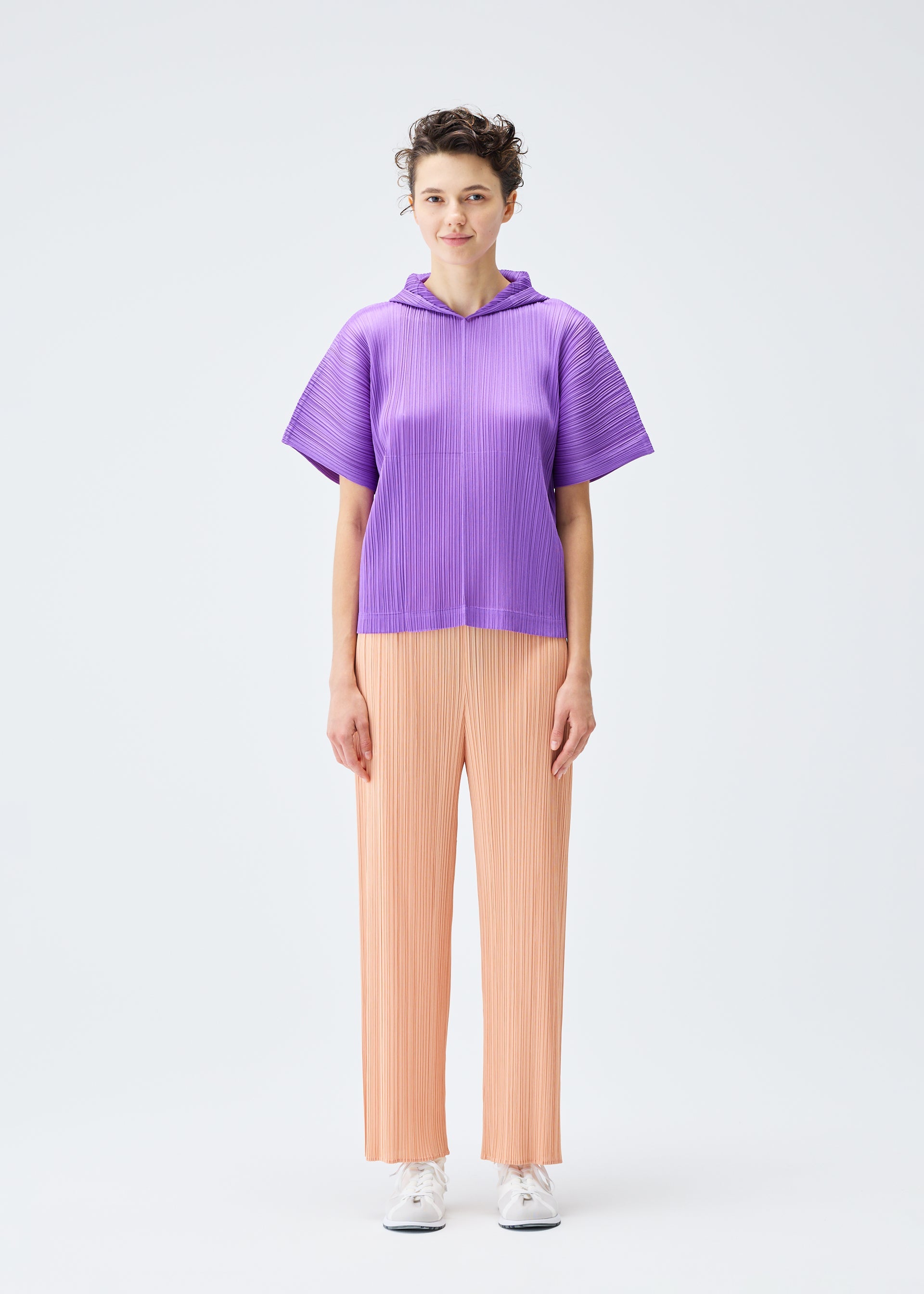 A model wears the PLEATS PLEASE ISSEY MIYAKE MONTHLY COLORS AUGUST trousers.