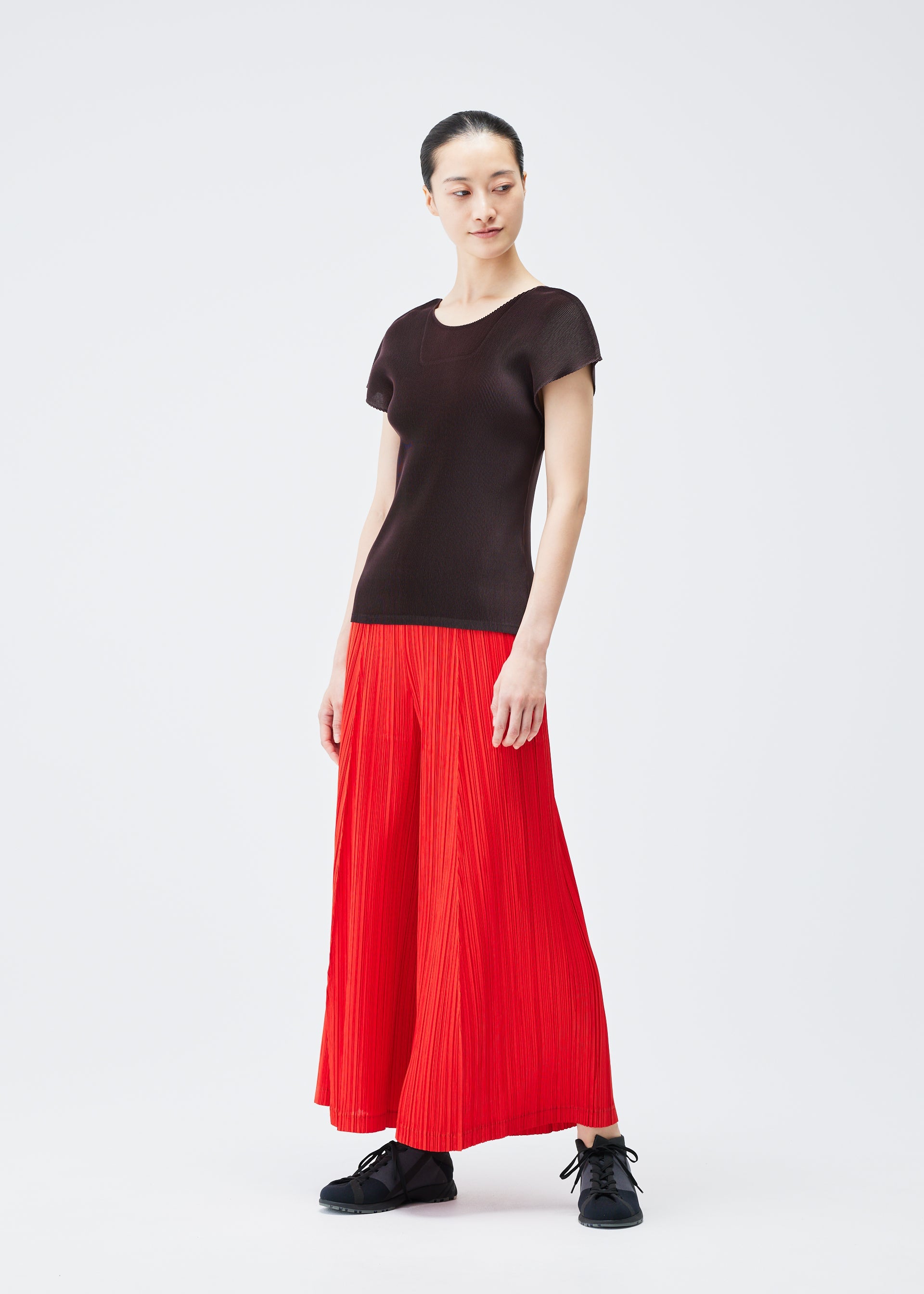 A model wears the PLEATS PLEASE ISSEY MIYAKE THICKER BOTTOMS 1 trousers.