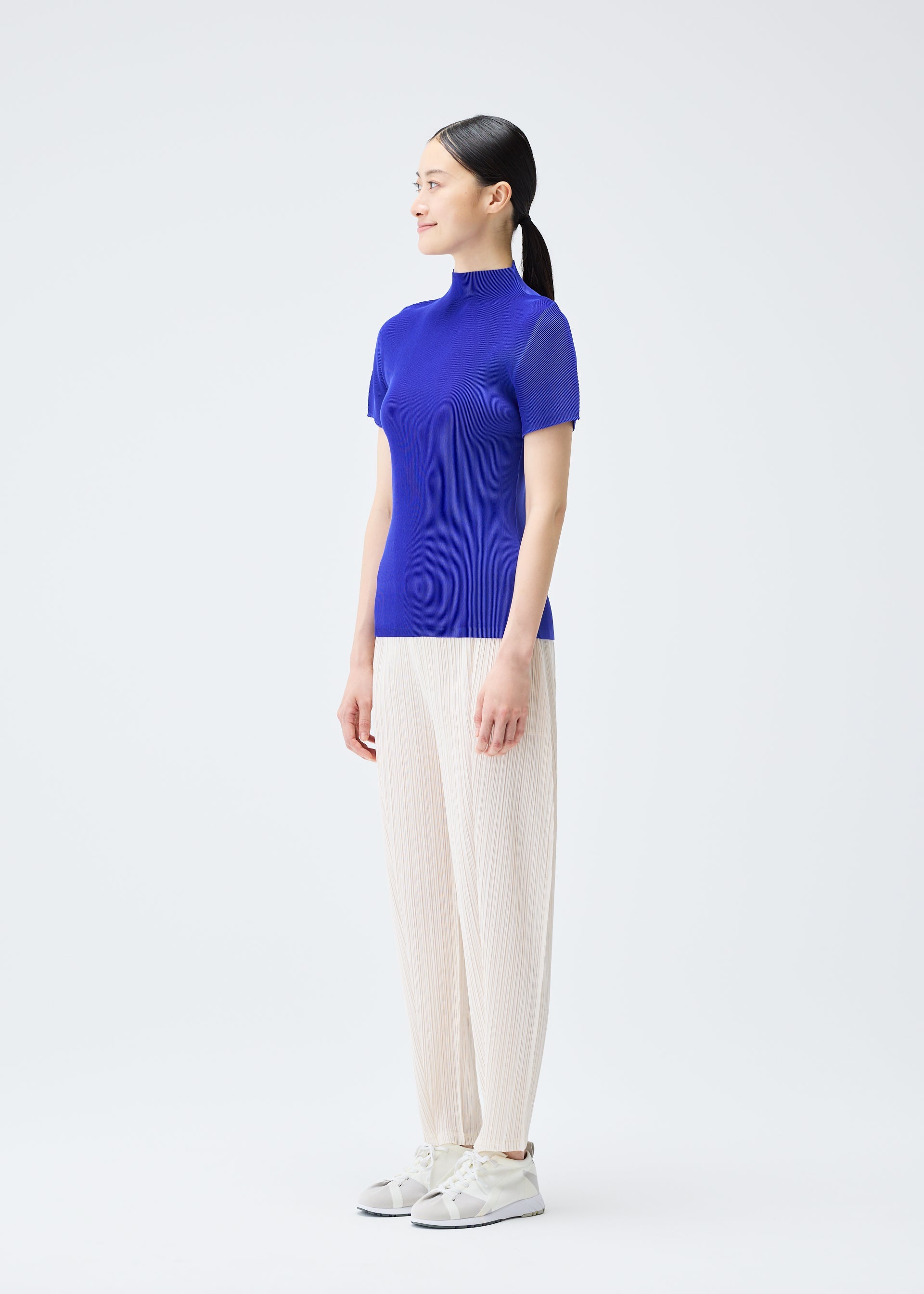 A model wears the PLEATS PLEASE ISSEY MIYAKE THICKER BOTTOMS 2 trousers.