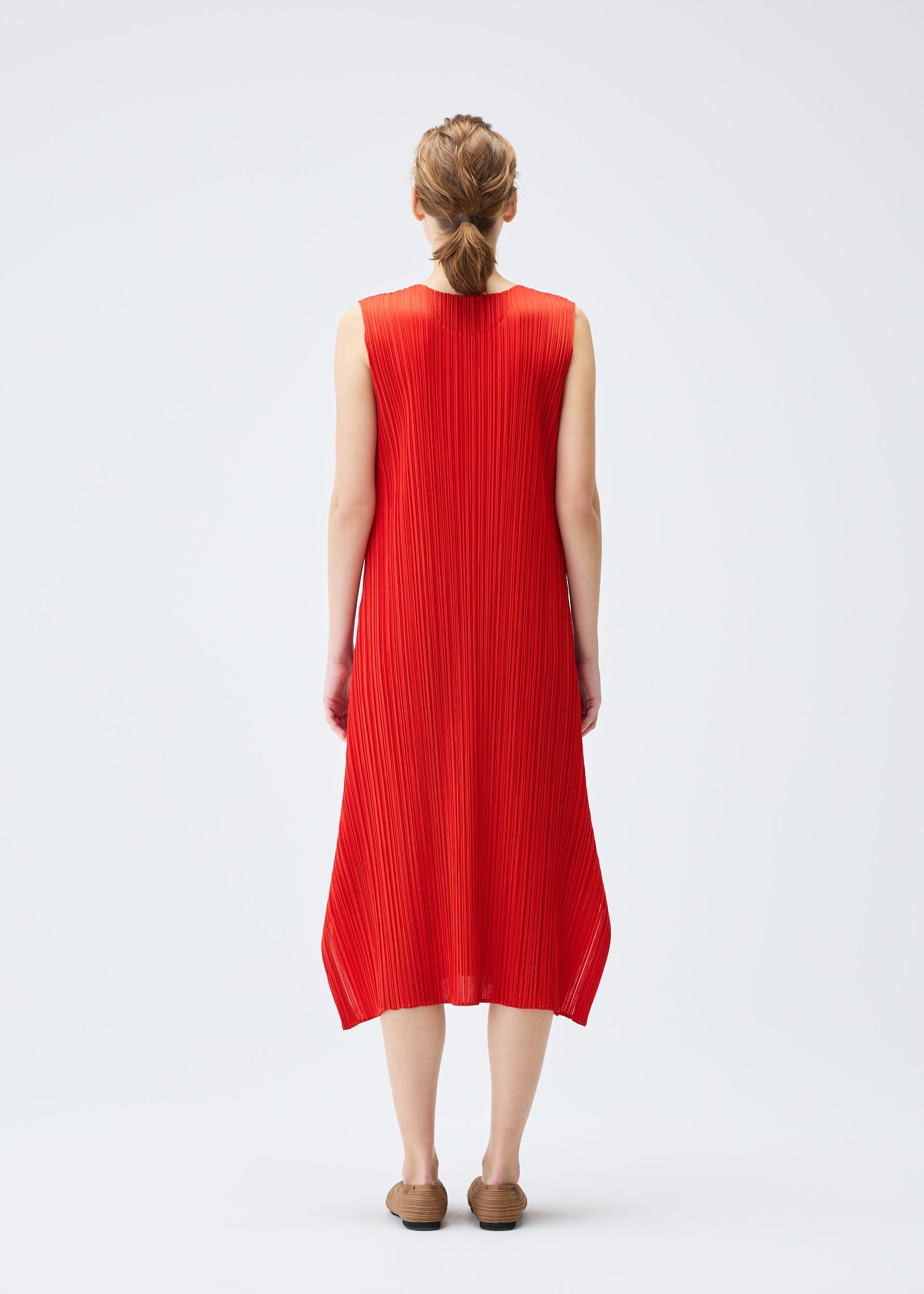 A model wears the PLEATS PLEASE ISSEY MIYAKE MONTHLY COLORS JULY dress.