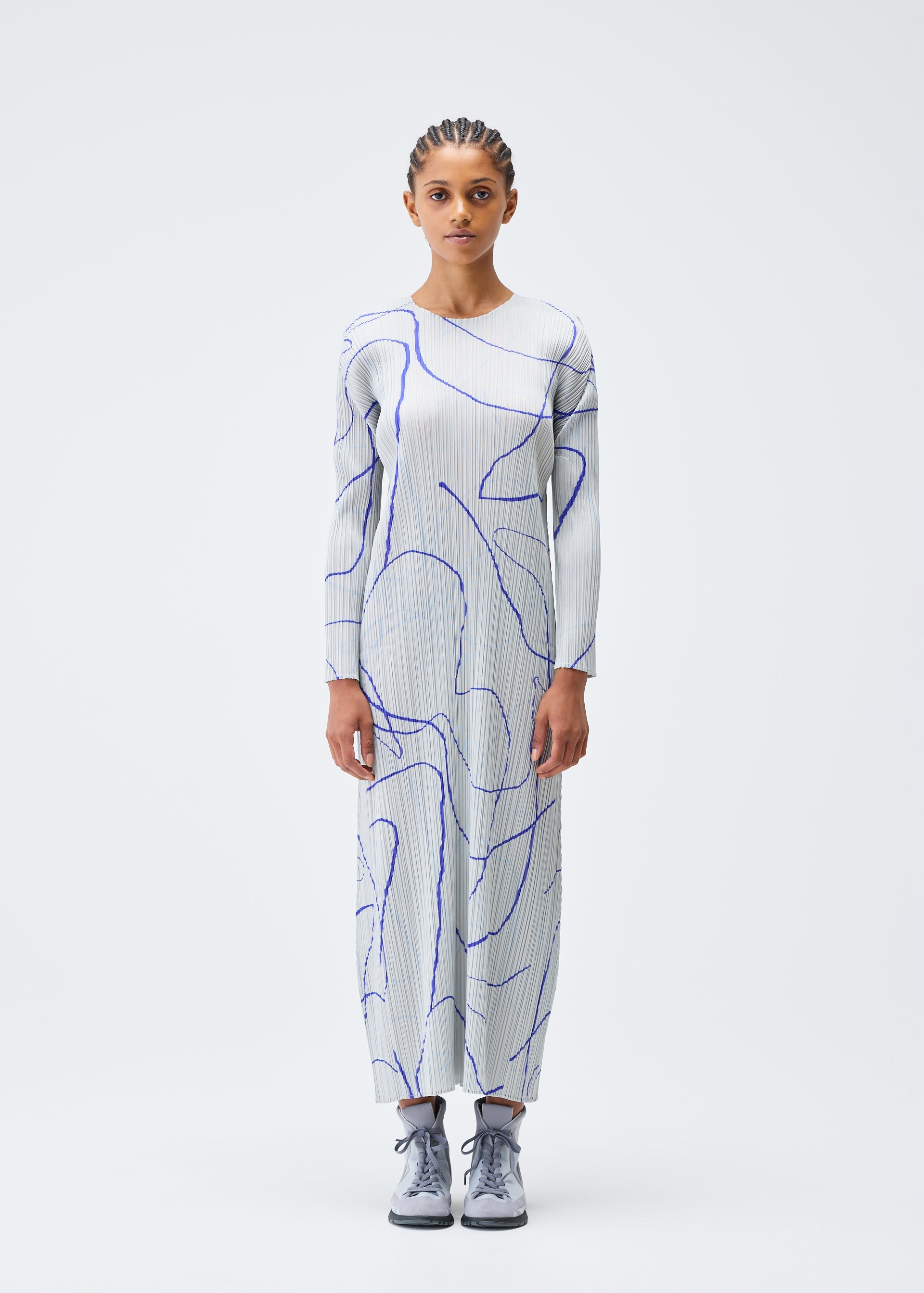 A model wears the PLEATS PLEASE ISSEY MIYAKE PAUSE dress.