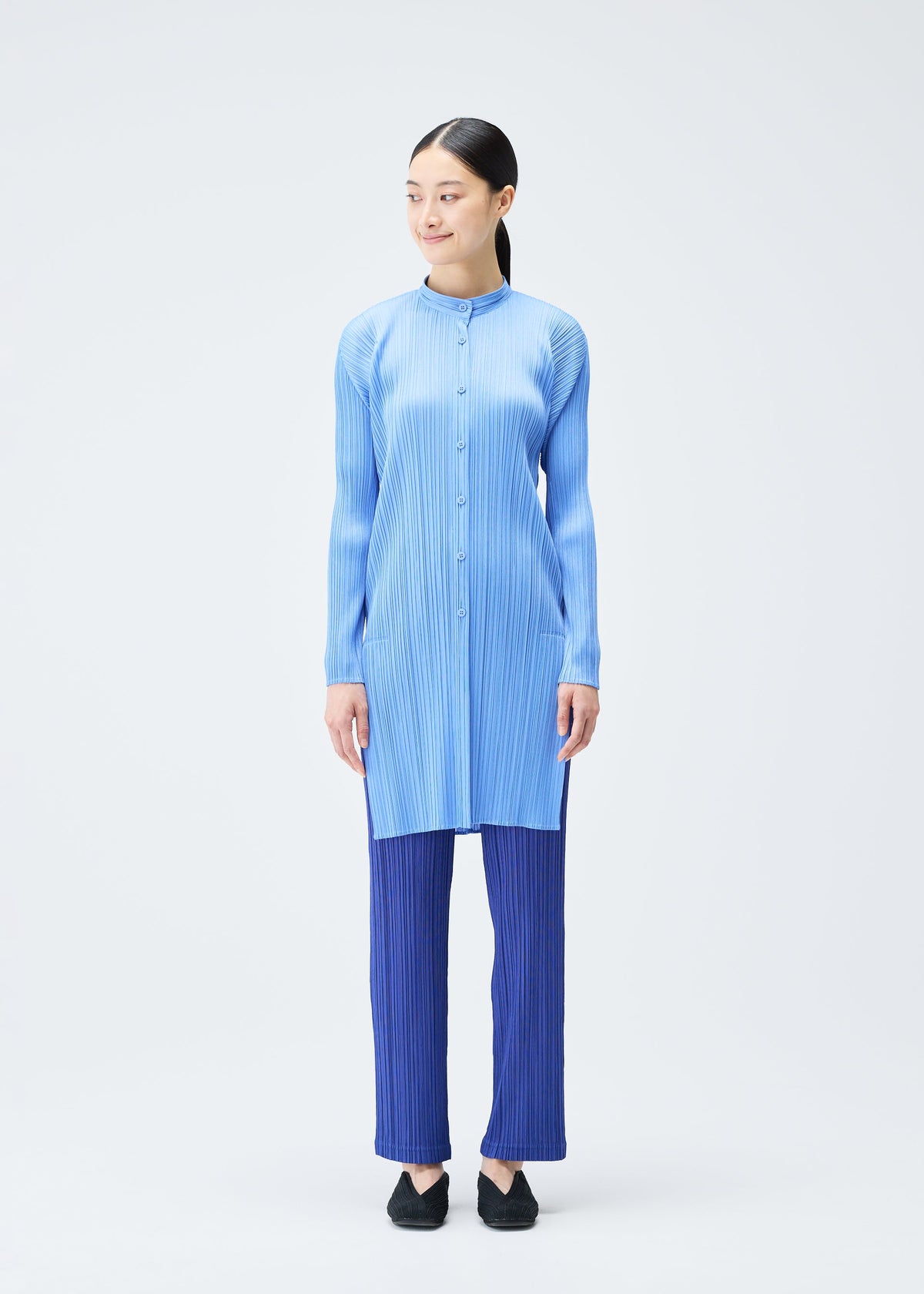 A model wears the PLEATS PLEASE ISSEY MIYAKE PLEATS SHIRT shirt.