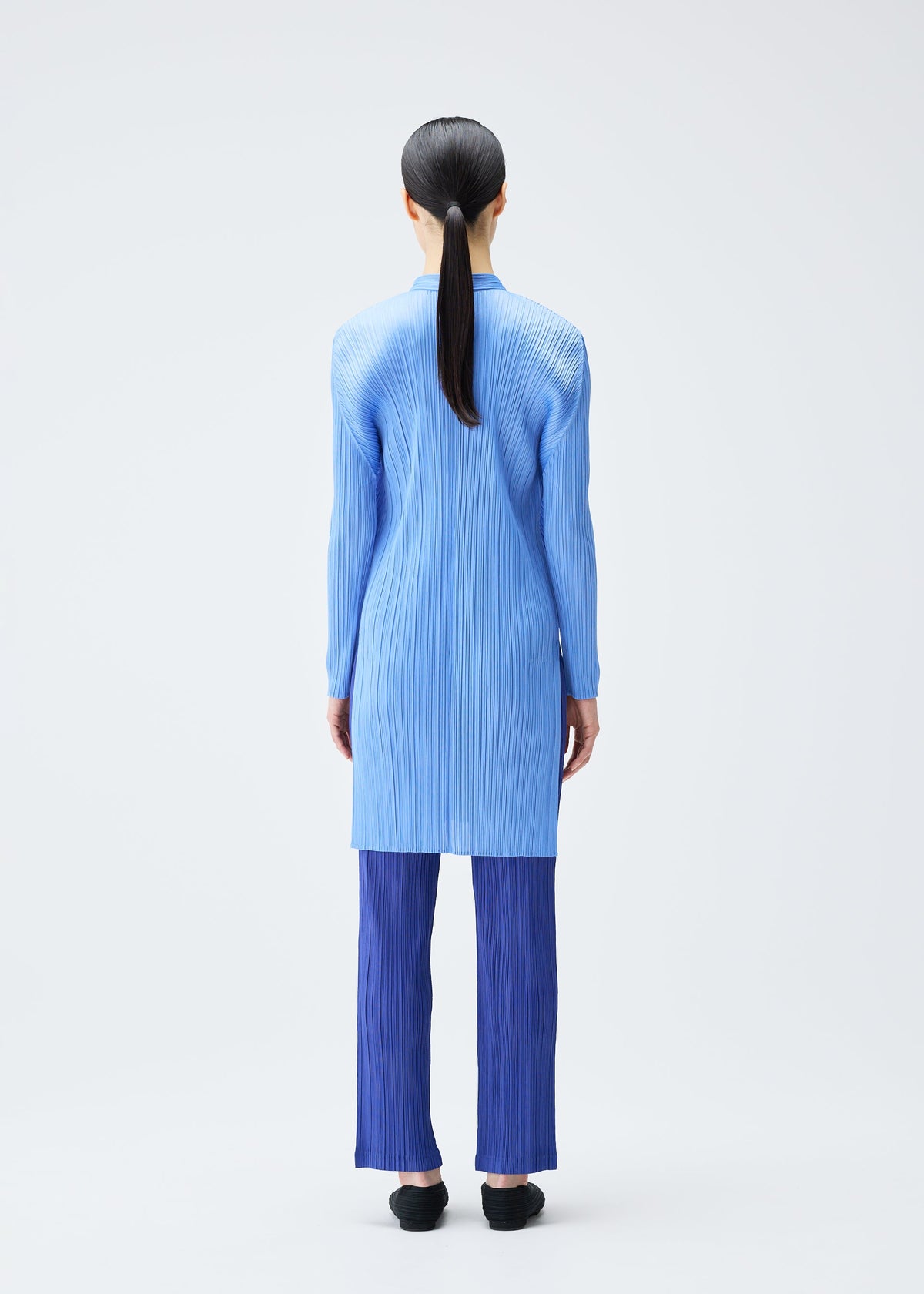 A model wears the PLEATS PLEASE ISSEY MIYAKE PLEATS SHIRT shirt.