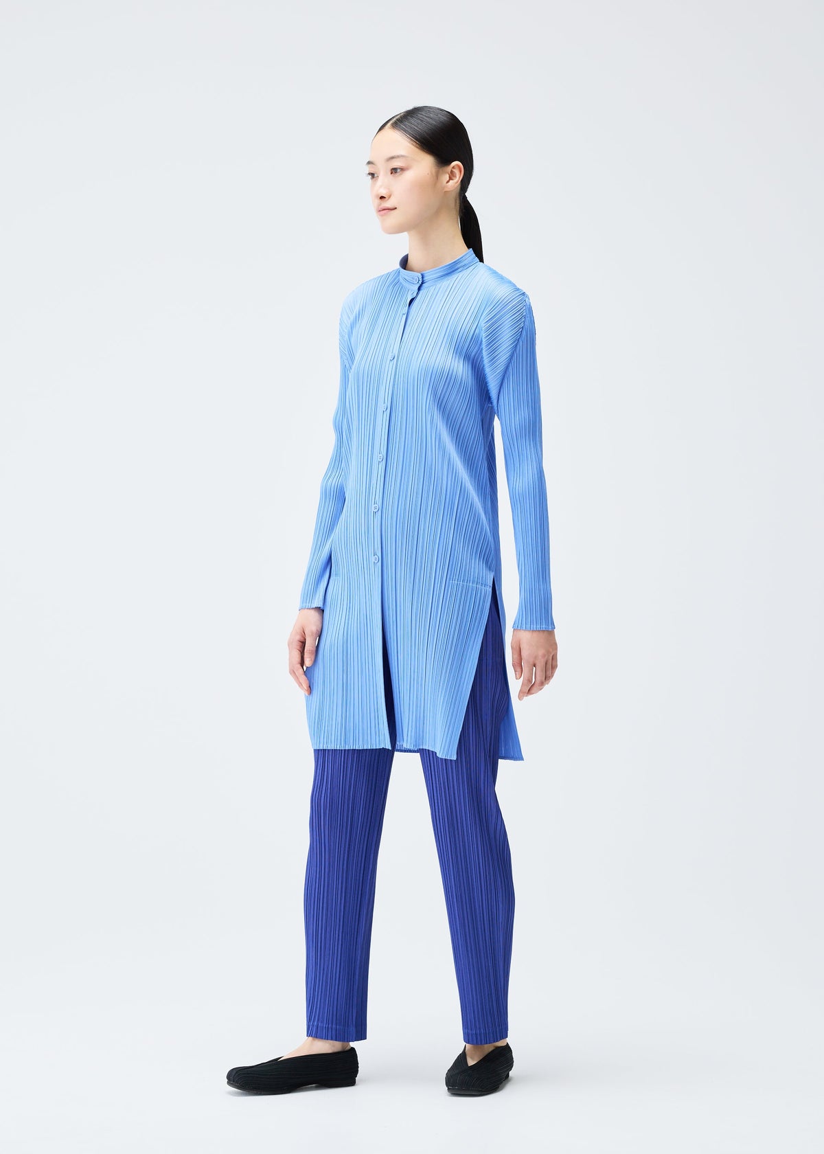 A model wears the PLEATS PLEASE ISSEY MIYAKE PLEATS SHIRT shirt.