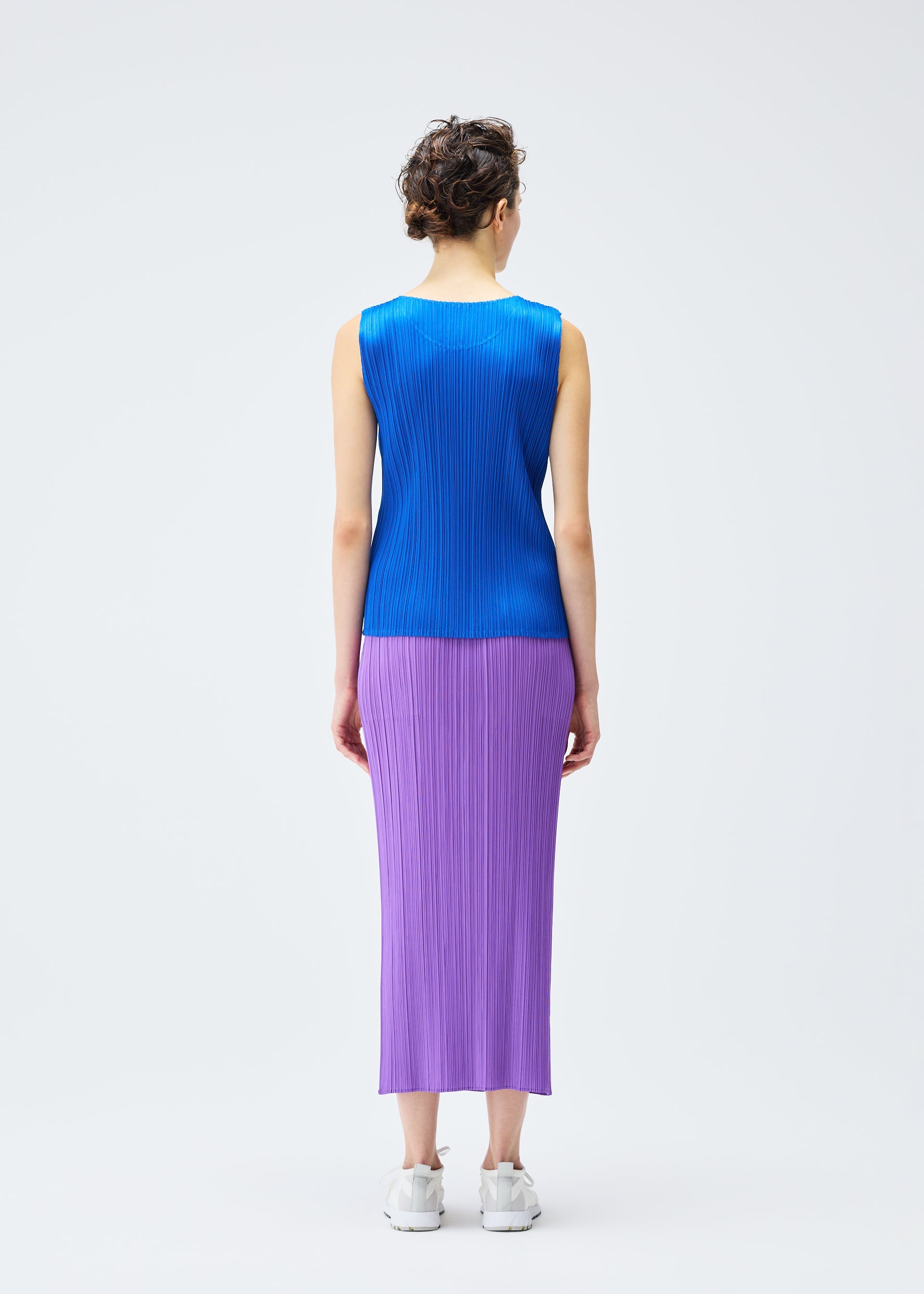 A model wears the PLEATS PLEASE ISSEY MIYAKE MONTHLY COLORS AUGUST top.