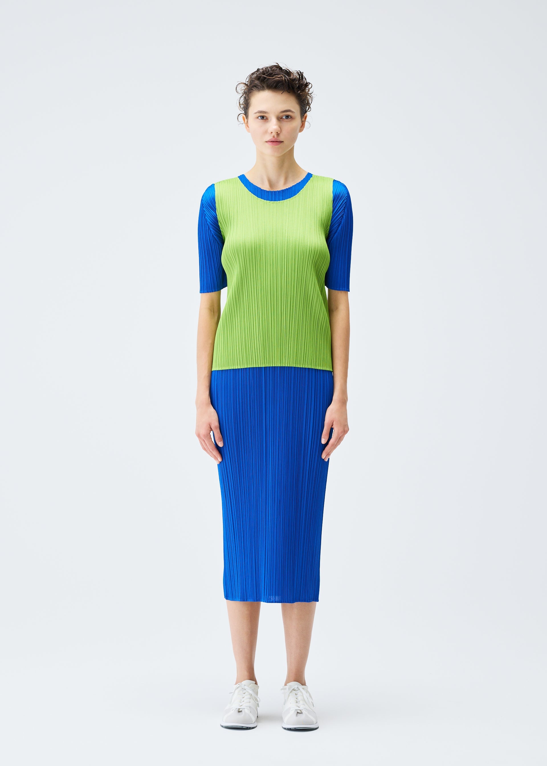 A model wears the PLEATS PLEASE ISSEY MIYAKE MONTHLY COLORS AUGUST top.