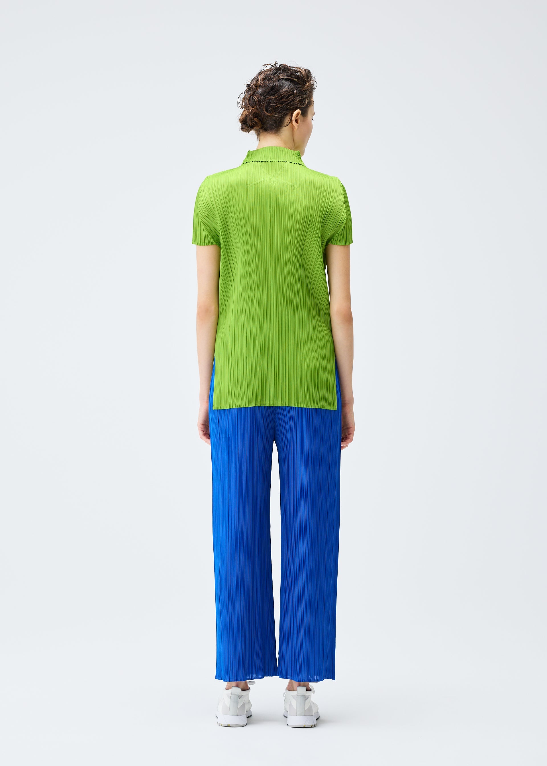 A model wears the PLEATS PLEASE ISSEY MIYAKE MONTHLY COLORS AUGUST top.