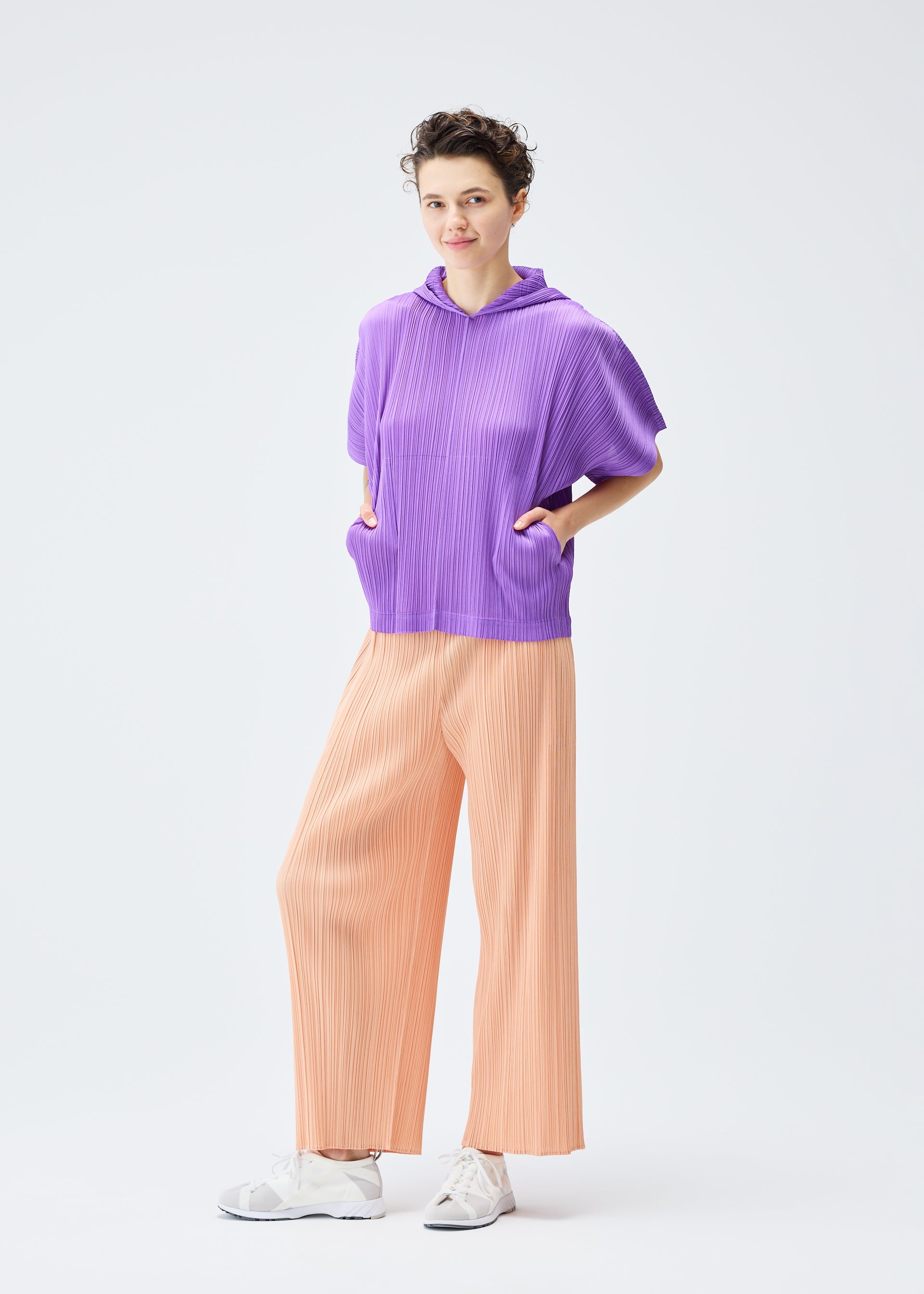 A model wears the PLEATS PLEASE ISSEY MIYAKE MONTHLY COLORS AUGUST top.