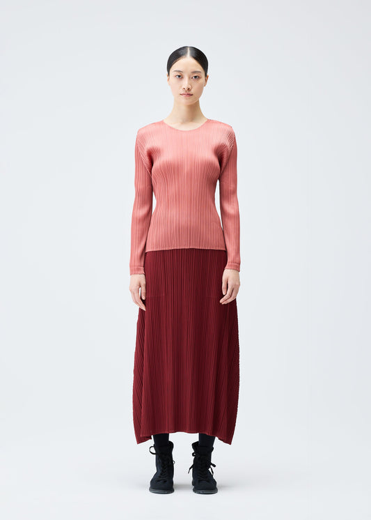 A model wears the PLEATS PLEASE ISSEY MIYAKE MONTHLY COLORS OCTOBER top.