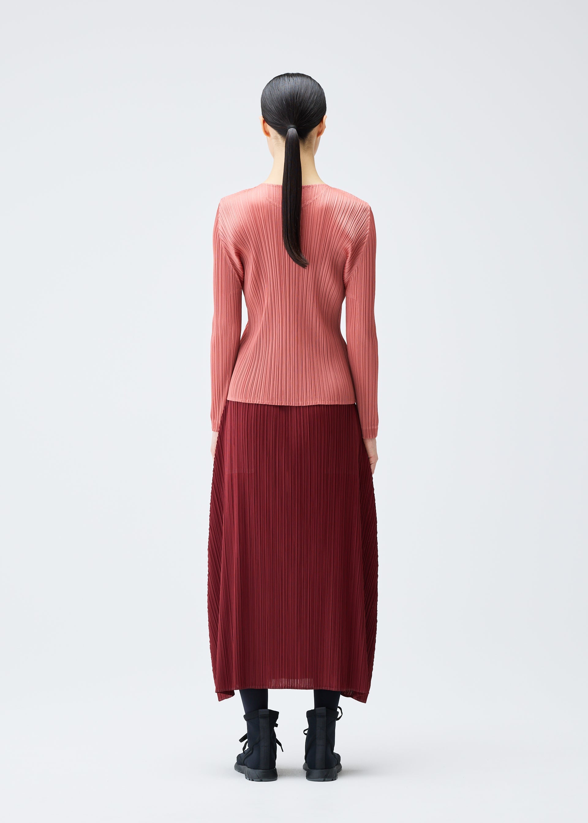 A model wears the PLEATS PLEASE ISSEY MIYAKE MONTHLY COLORS OCTOBER top.