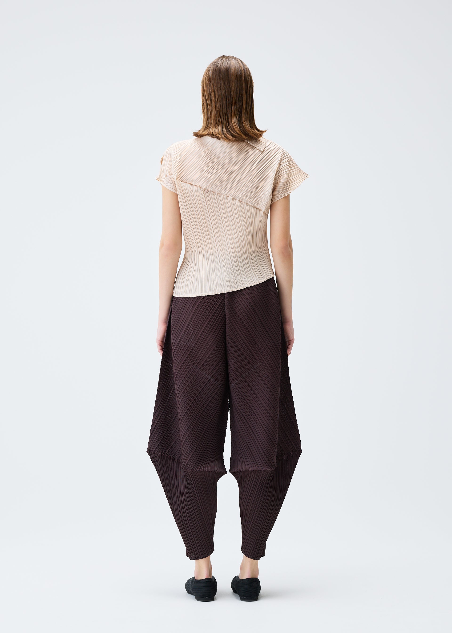 A model wears the PLEATS PLEASE ISSEY MIYAKE LEAP top.