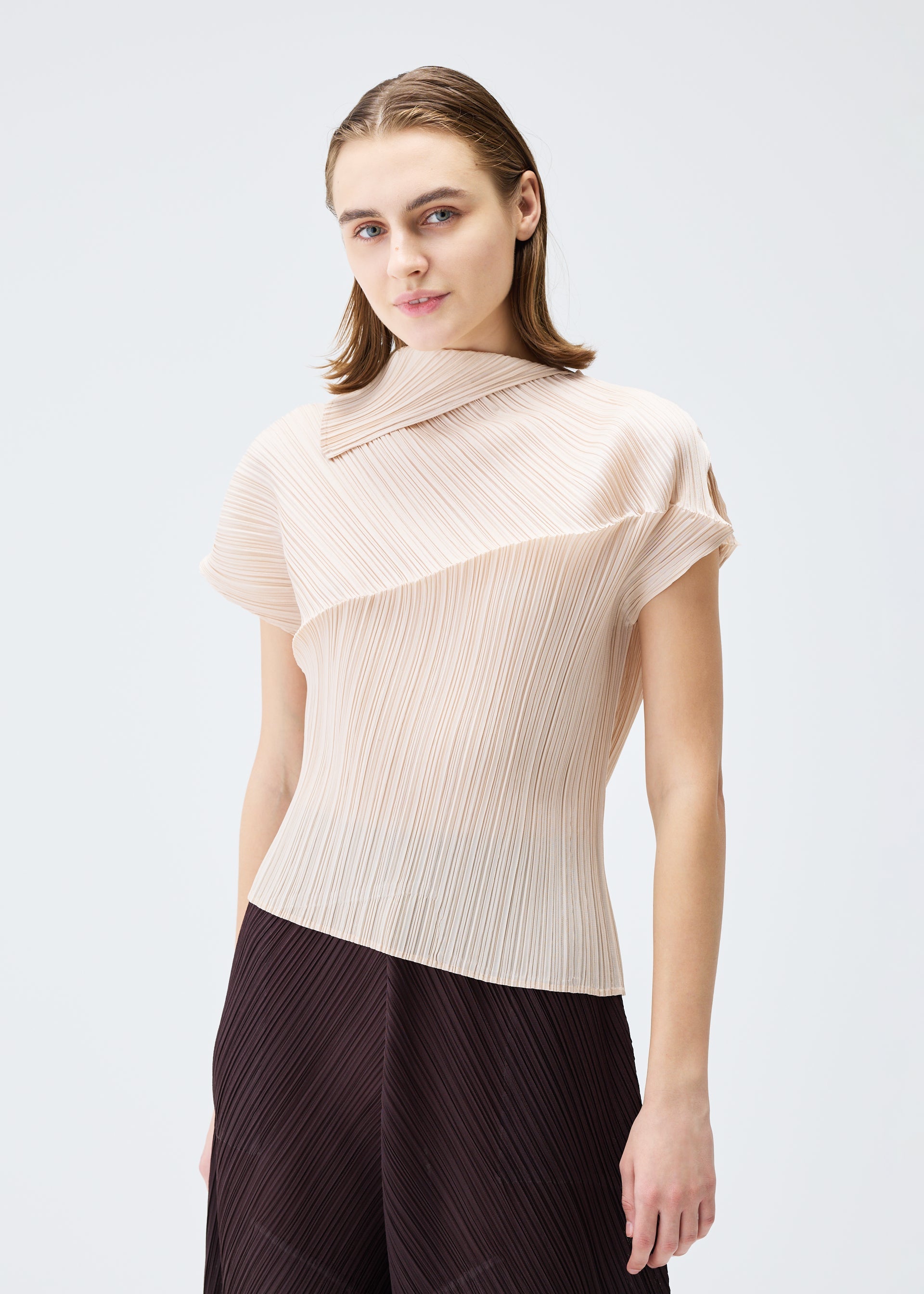 A model wears the PLEATS PLEASE ISSEY MIYAKE LEAP top.