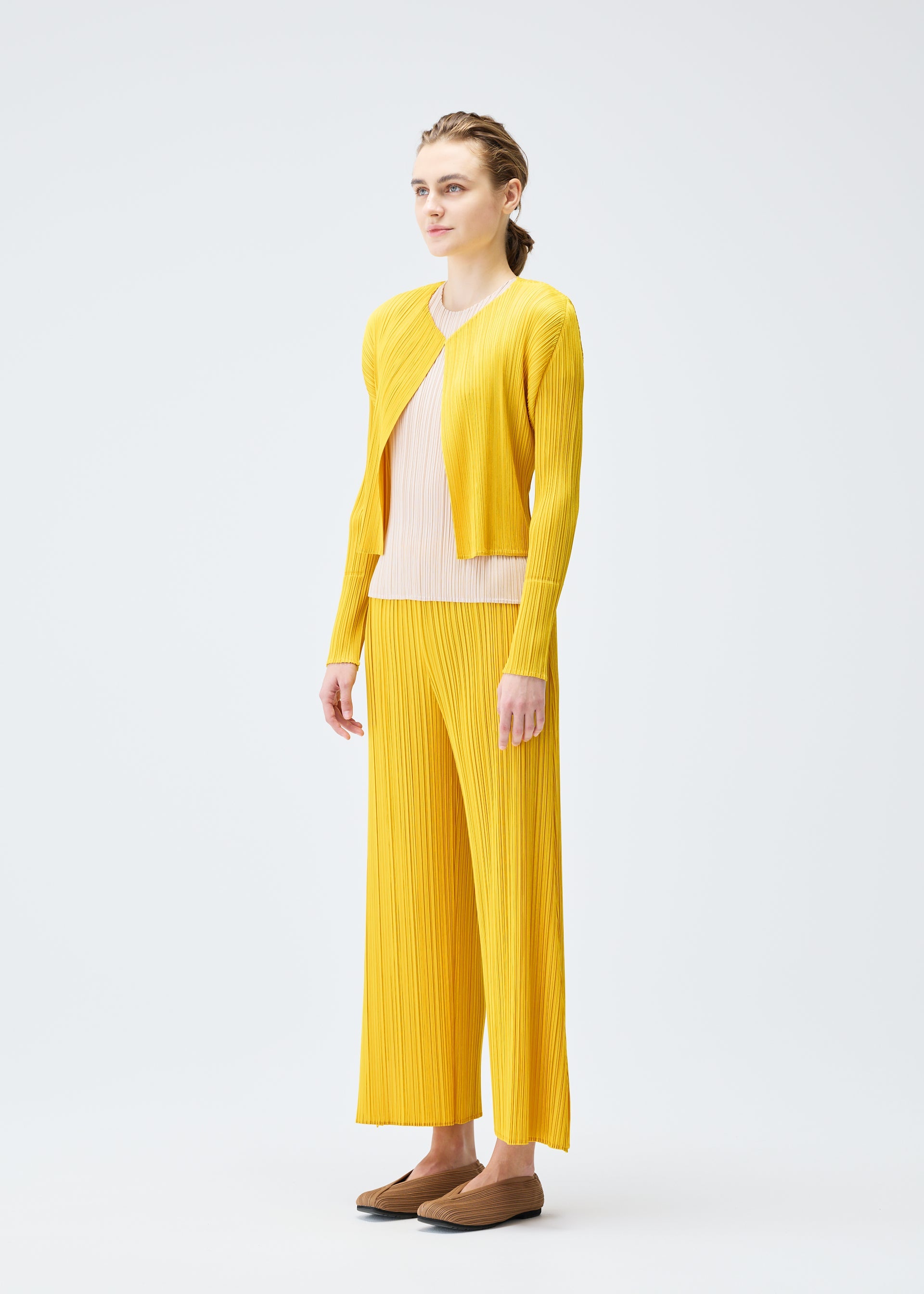 A model wears the PLEATS PLEASE ISSEY MIYAKE MONTHLY COLORS JULY cardigan.