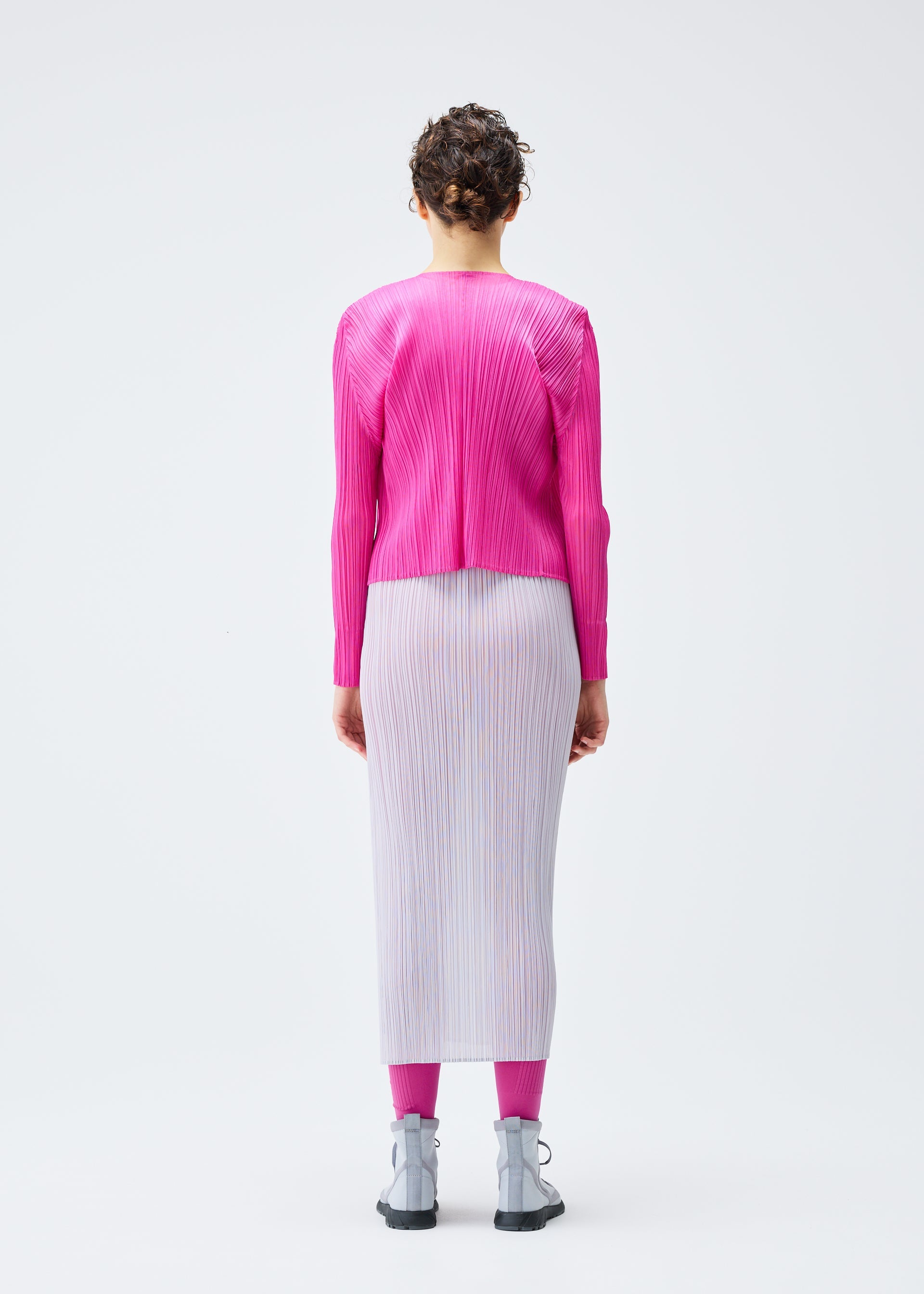 A model wears the PLEATS PLEASE ISSEY MIYAKE LUCID PLEATS cardigan.