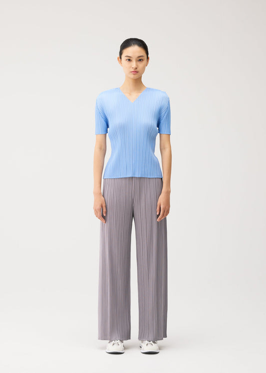 A model wears the PLEATS PLEASE ISSEY MIYAKE MONTHLY COLORS : AUGUST monthly-colors-august-v-neck-top-off-white.