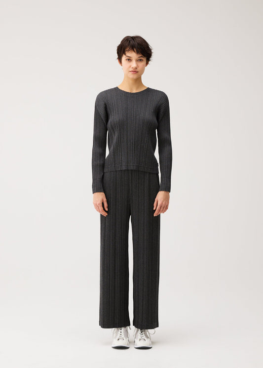 A model wears the PLEATS PLEASE ISSEY MIYAKE COTTON DENIM BLACK cotton-denim-black-top-black.