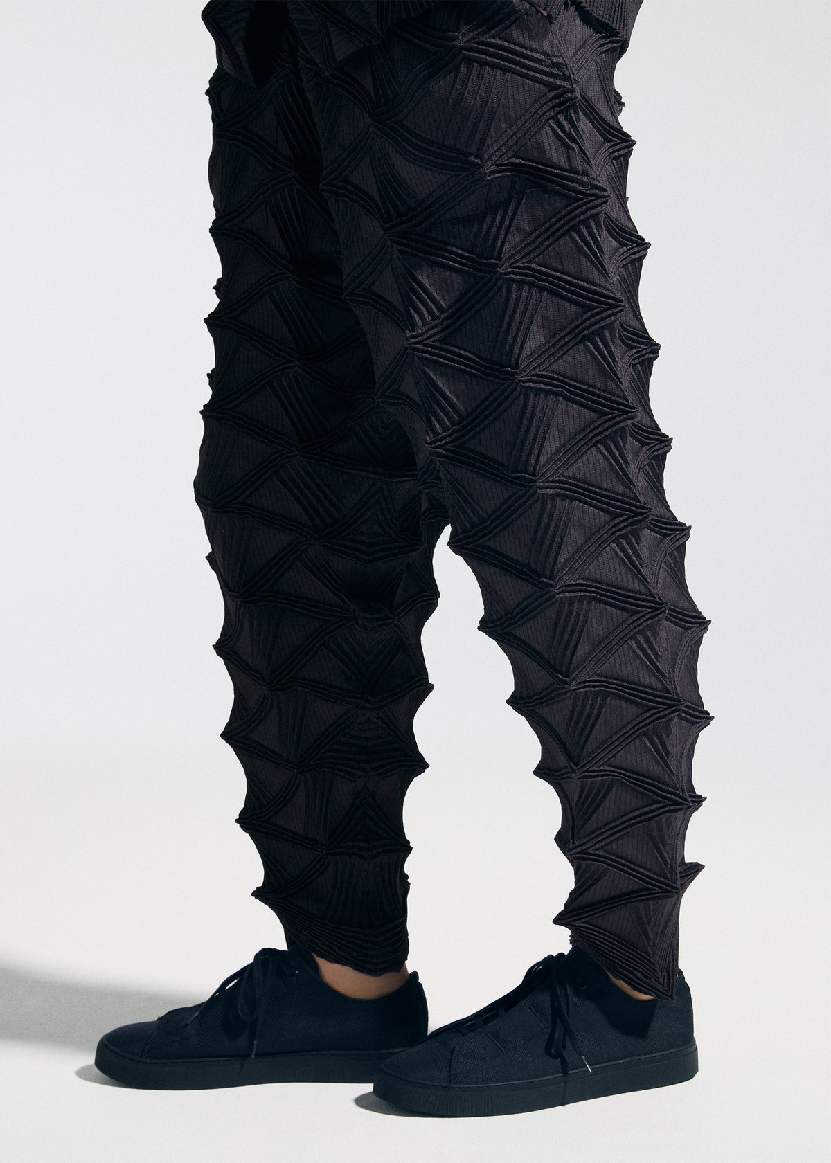 A model wears the A-POC ABLE ISSEY MIYAKE TYPE-O 023 type-o-023-trousers-black.