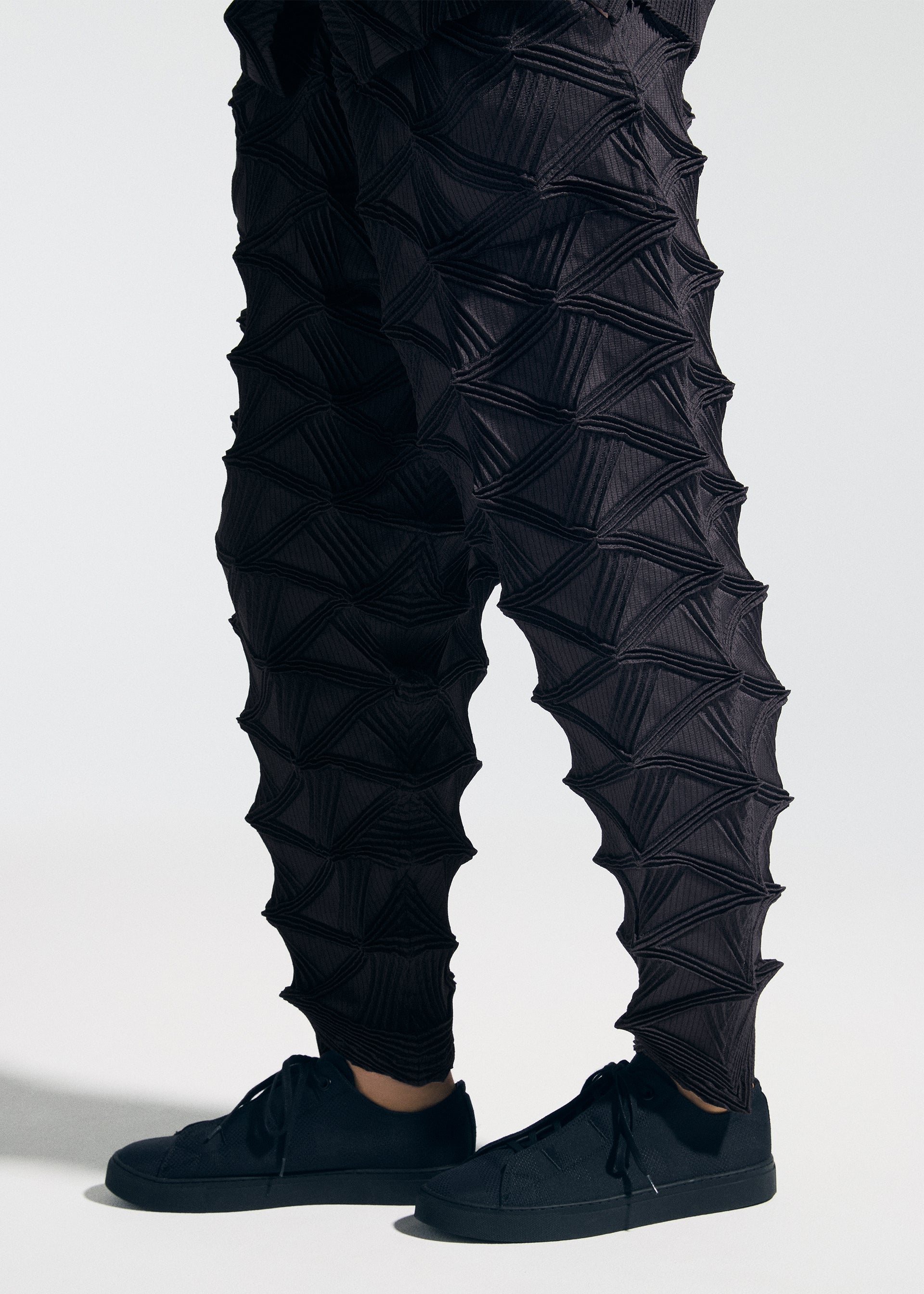 A model wears the A-POC ABLE ISSEY MIYAKE TYPE-O 023 type-o-023-trousers-black.
