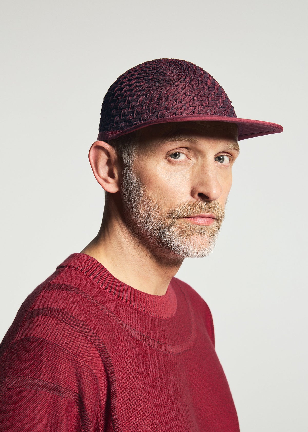 A model wears the A-POC ABLE ISSEY MIYAKE TYPE-O CAP type-o-cap-cap-ivory.