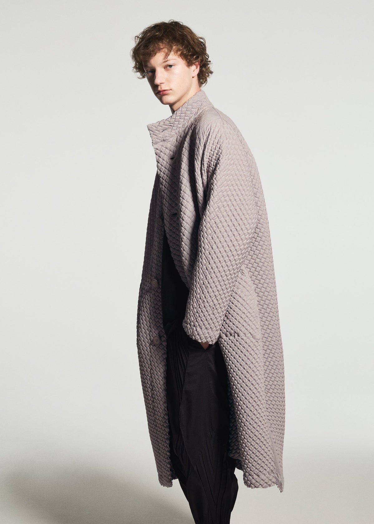 A model wears the A-POC ABLE ISSEY MIYAKE TYPE-O 024 type-o-024-coat-black.