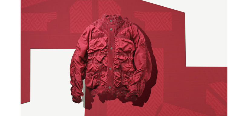 Centre: TYPE-O 021 Jacket in Scarlet Red suspended mid-air. Background: Scarlet Red fabric featuring a cut out pattern against a white background. 