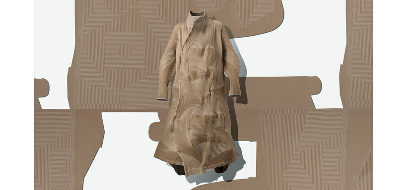 Centre: TYPE-O 020 Coat in Beige suspended mid-air. Background: Beige fabric featuring a cut out pattern against a white background.