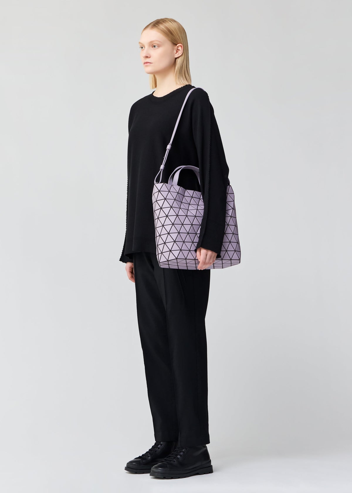 A model wears the BAO BAO ISSEY MIYAKE CRYSTAL MATTE hand bag.